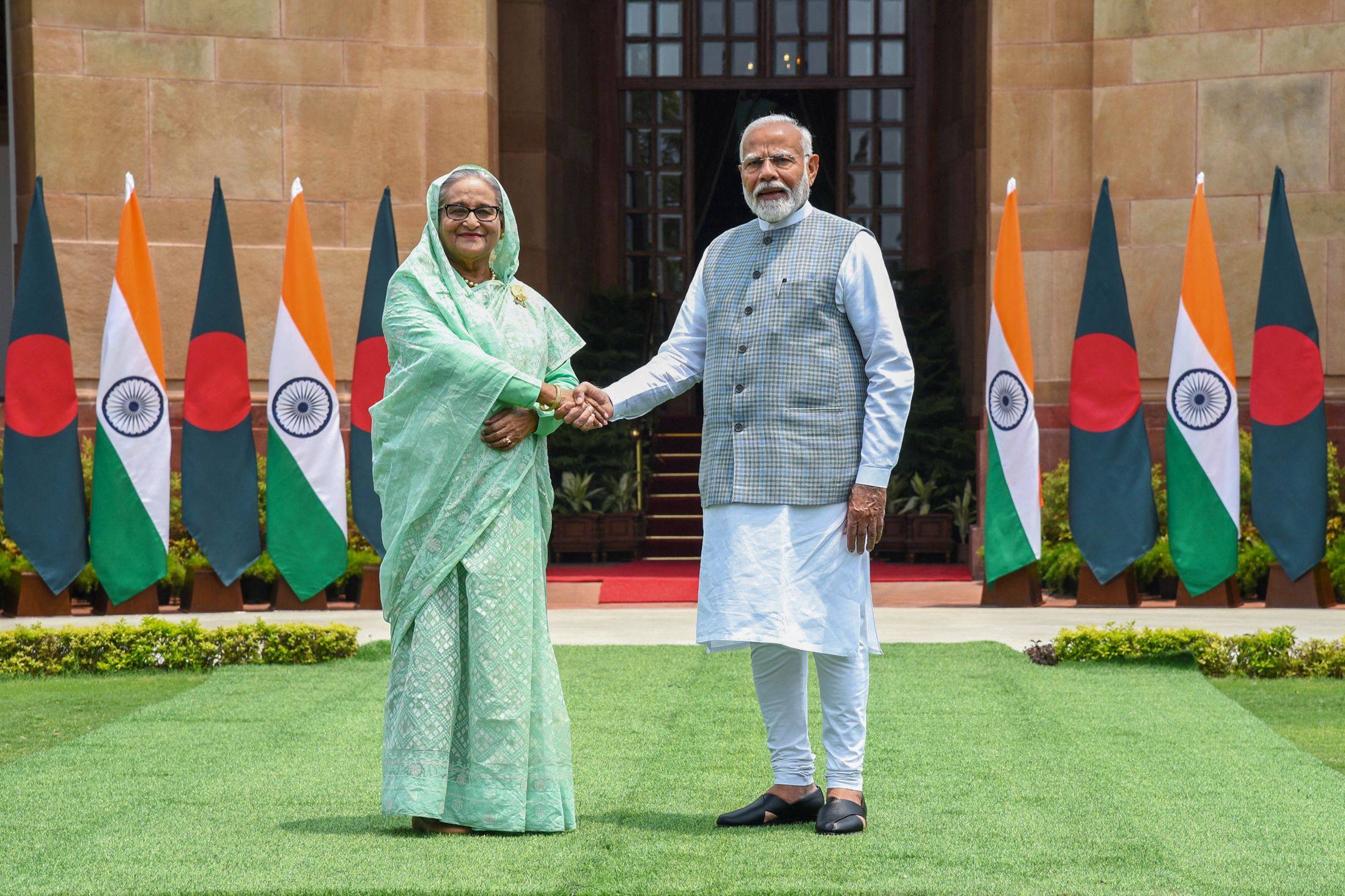 India’s Prime Minister Narendra Modi shakes hands with his Bangladesh counterpart Sheikh Hasina upon their arrival at the Hyderabad house in New Delhi. Photo: Indian Press Information Bureau (PIB) / AFP