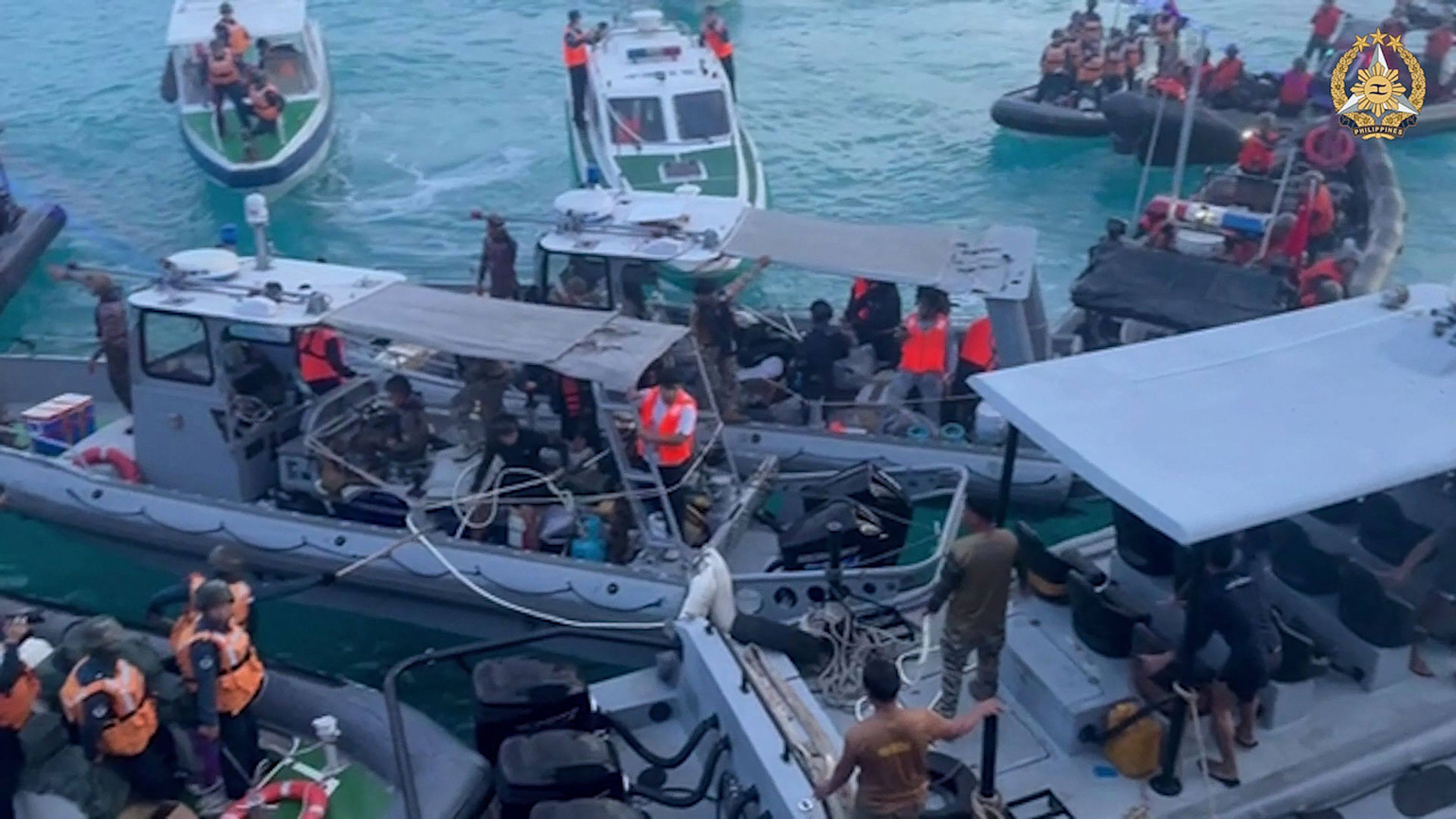 Chinese coastguard personnel (left and right) aboard their inflatable boats blocking Philippine navy boats (centre) in the disputed South China Sea on June 17. Photo: AFP
