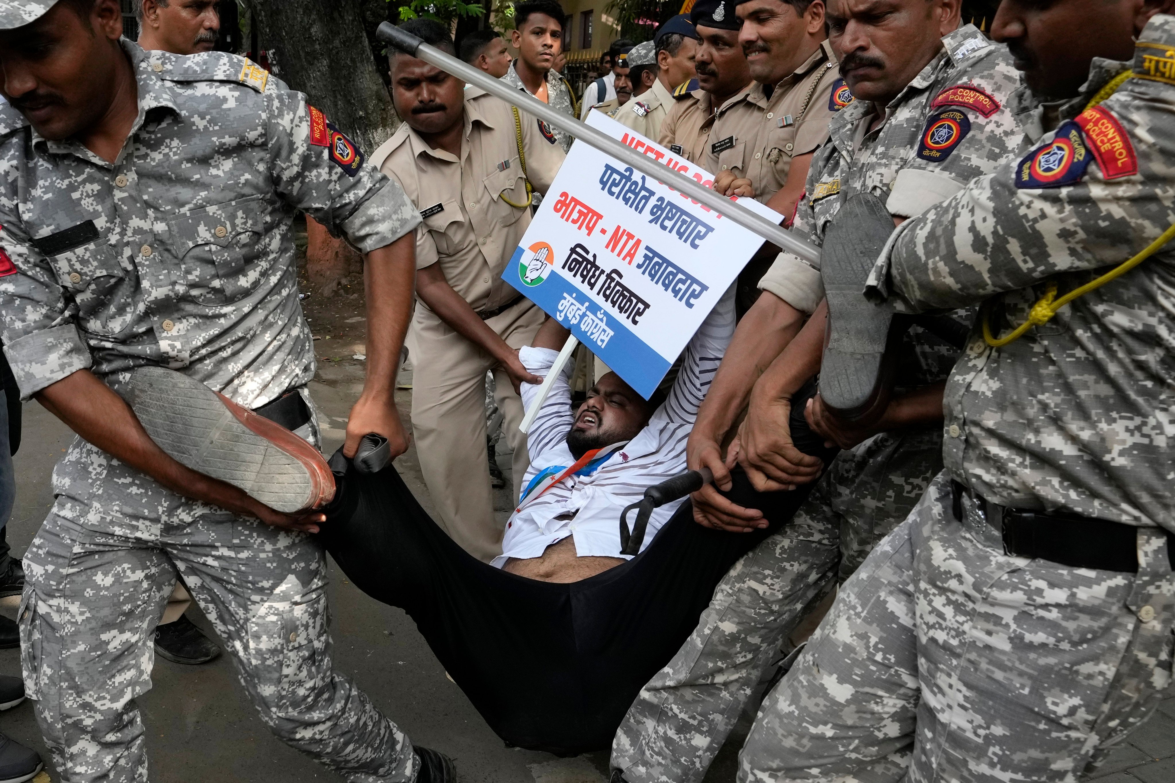 Police officials detain a Congress party worker who held a demonstration to demand justice for students affected by the alleged irregularities in the National Eligibility cum Entrance Examination (NEET) in Mumbai, India on June 21. Photo: AP