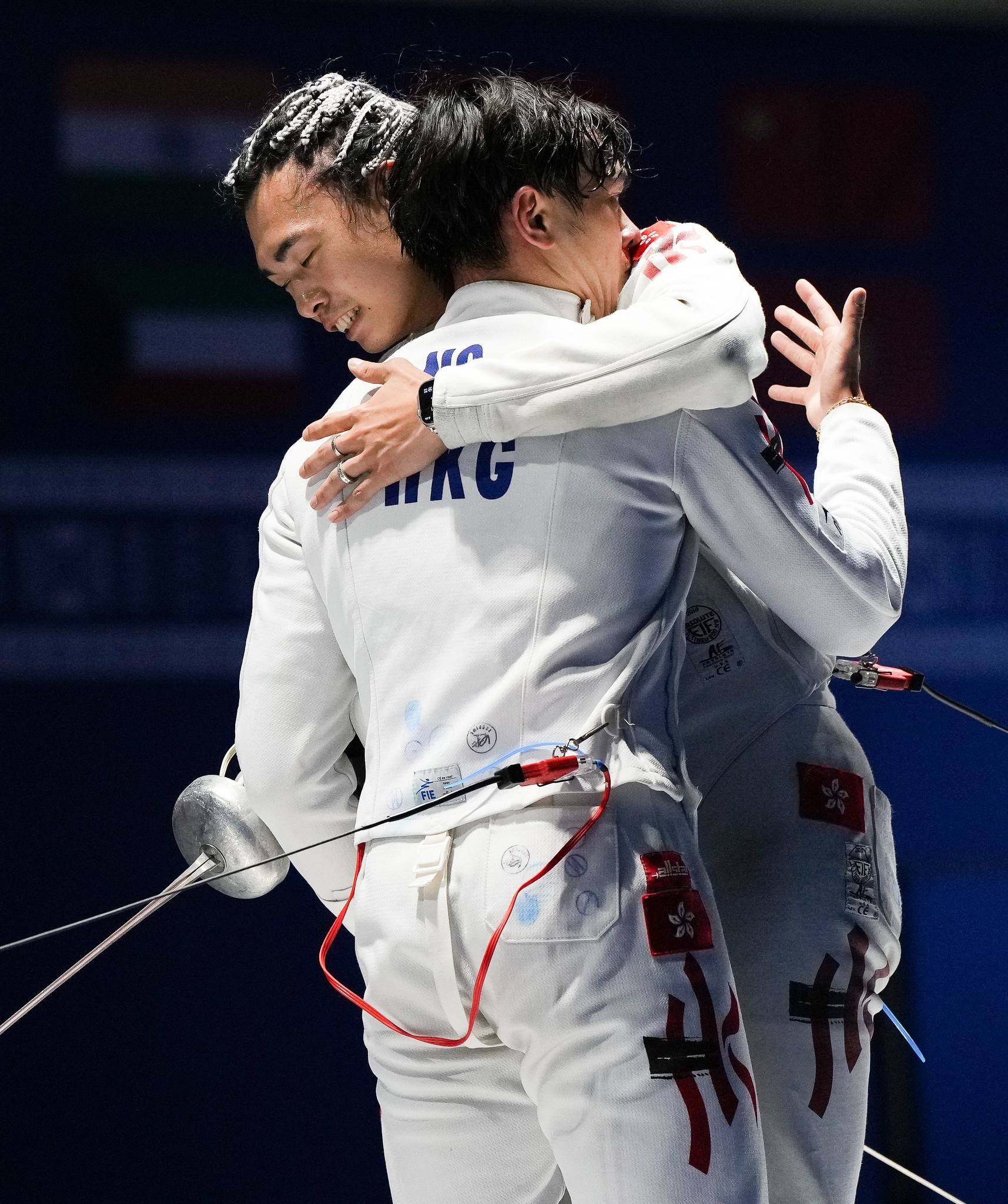 Hong Kong pair Cedric Ho (right) and Anson Ng embrace after the men’s épée final in Kuwait. Photo: FIE