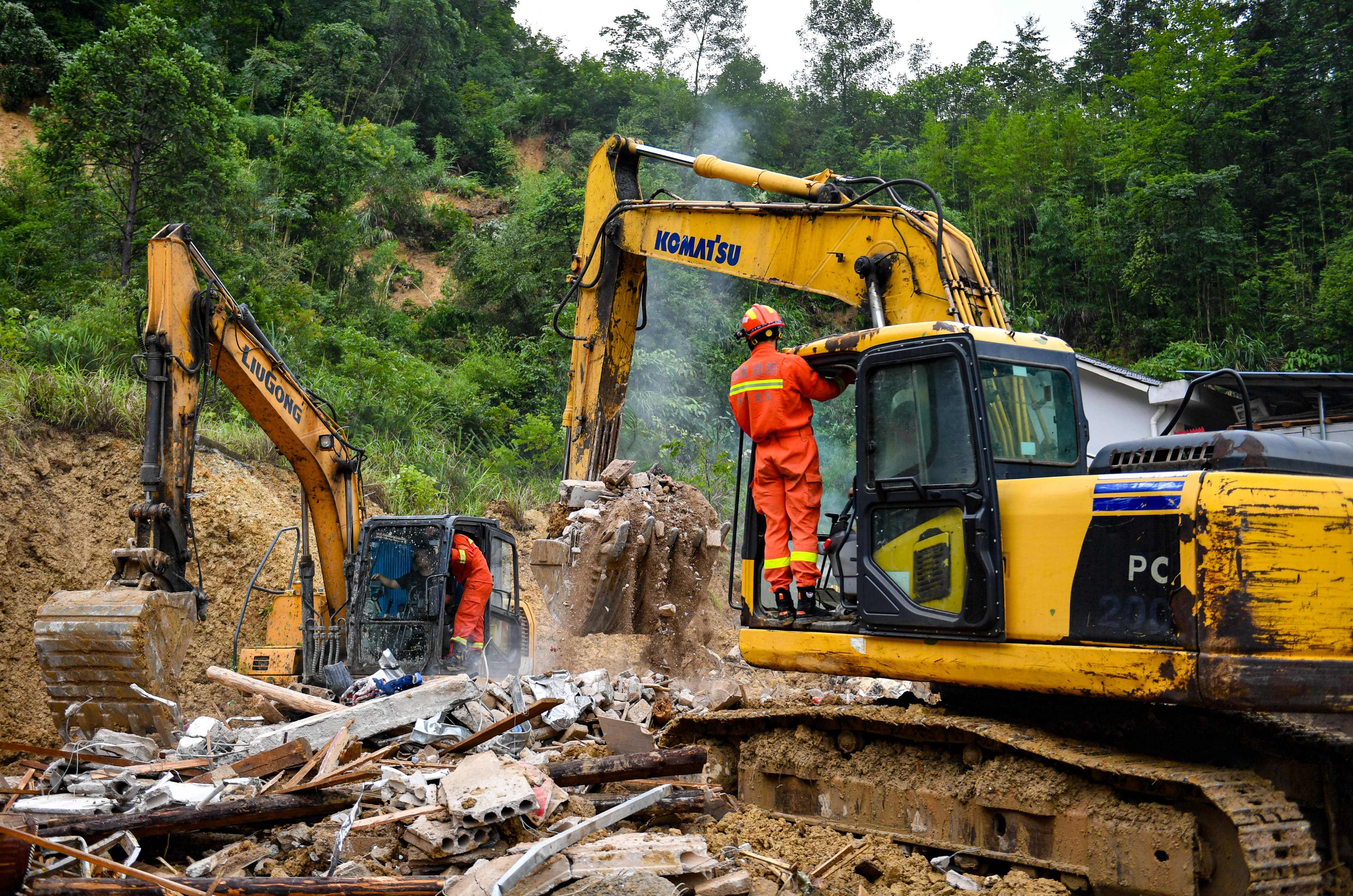 Rescuers use heavy machinery to shift the rubble as they search for eight people who were later found dead in a landslide in Hunan province, central China on Sunday. Photo: Xinhua