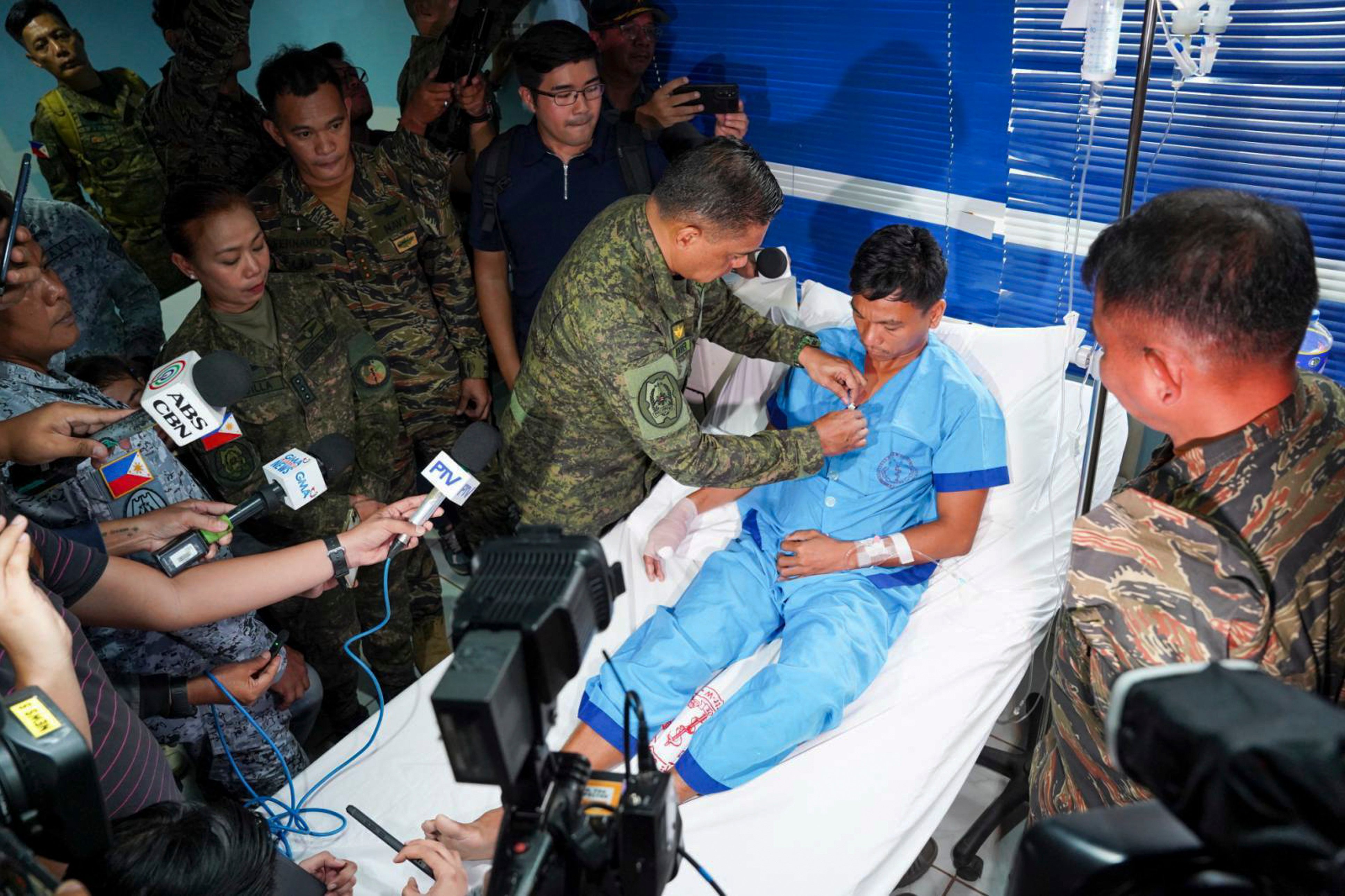 Philippine military chief General Romeo Brawner Jnr pins a medal on Jeffrey Facundo, who lost a thumb in the clash on June 17. Photo: Handout/Armed Forces of the Philippines/AP