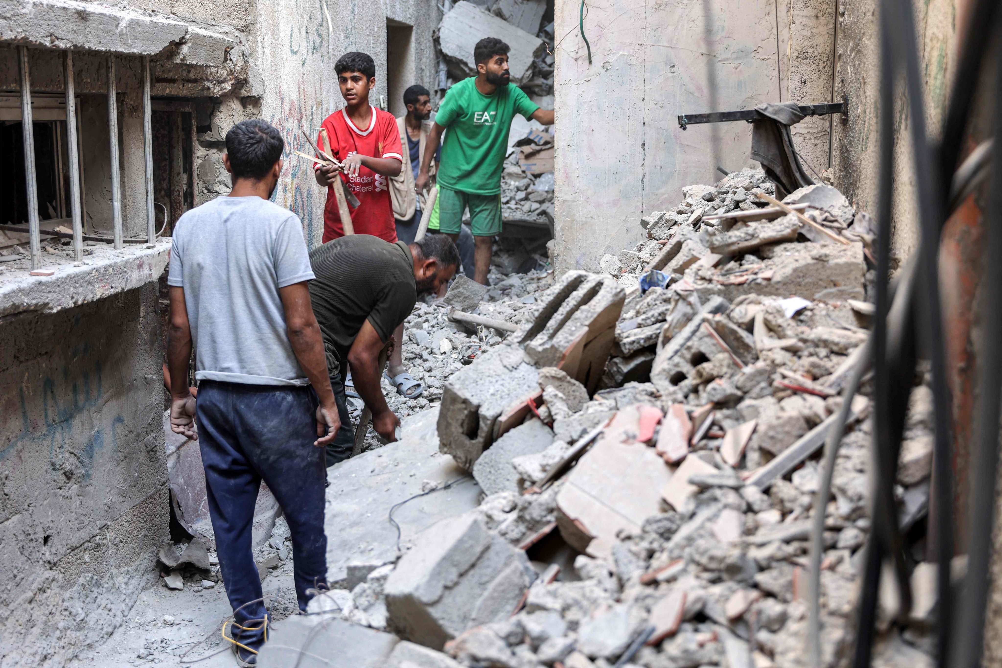 Men search through the rubble of the house of the sister of Ismail Haniyeh, the Doha-based political bureau chief of the Palestinian Islamist movement Hamas, after it was hit by Israeli bombardment on Tuesday. Photo: AFP