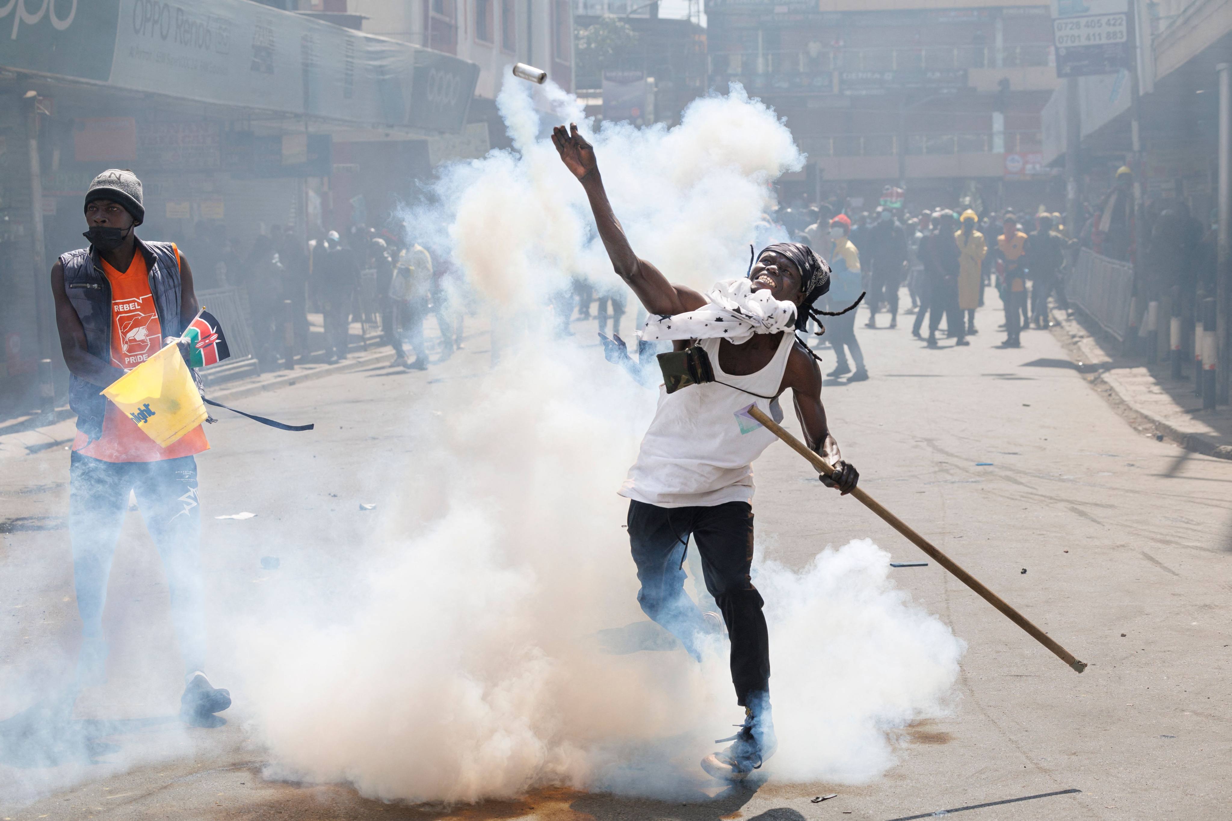 A protester lobs back a teargas canister at police in downtown Nairobi. Photo: AFP