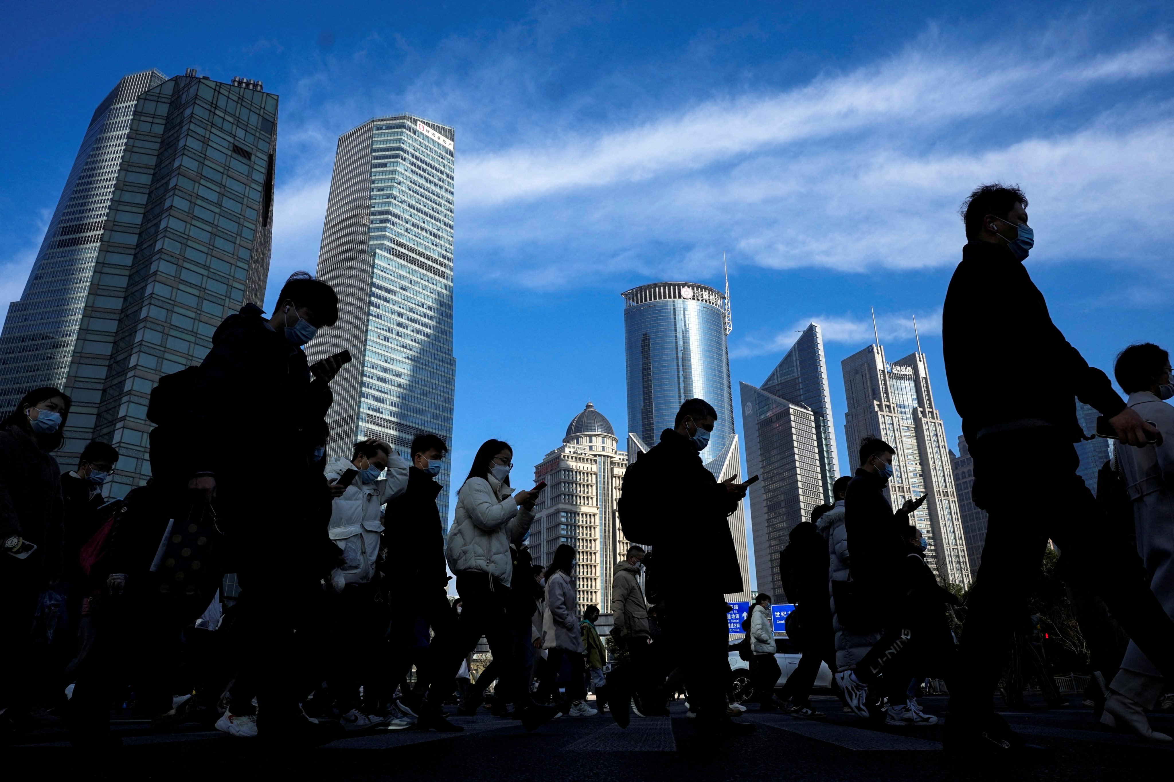 People cross a street near office towers in the Lujiazui financial district. Photo: Reuters