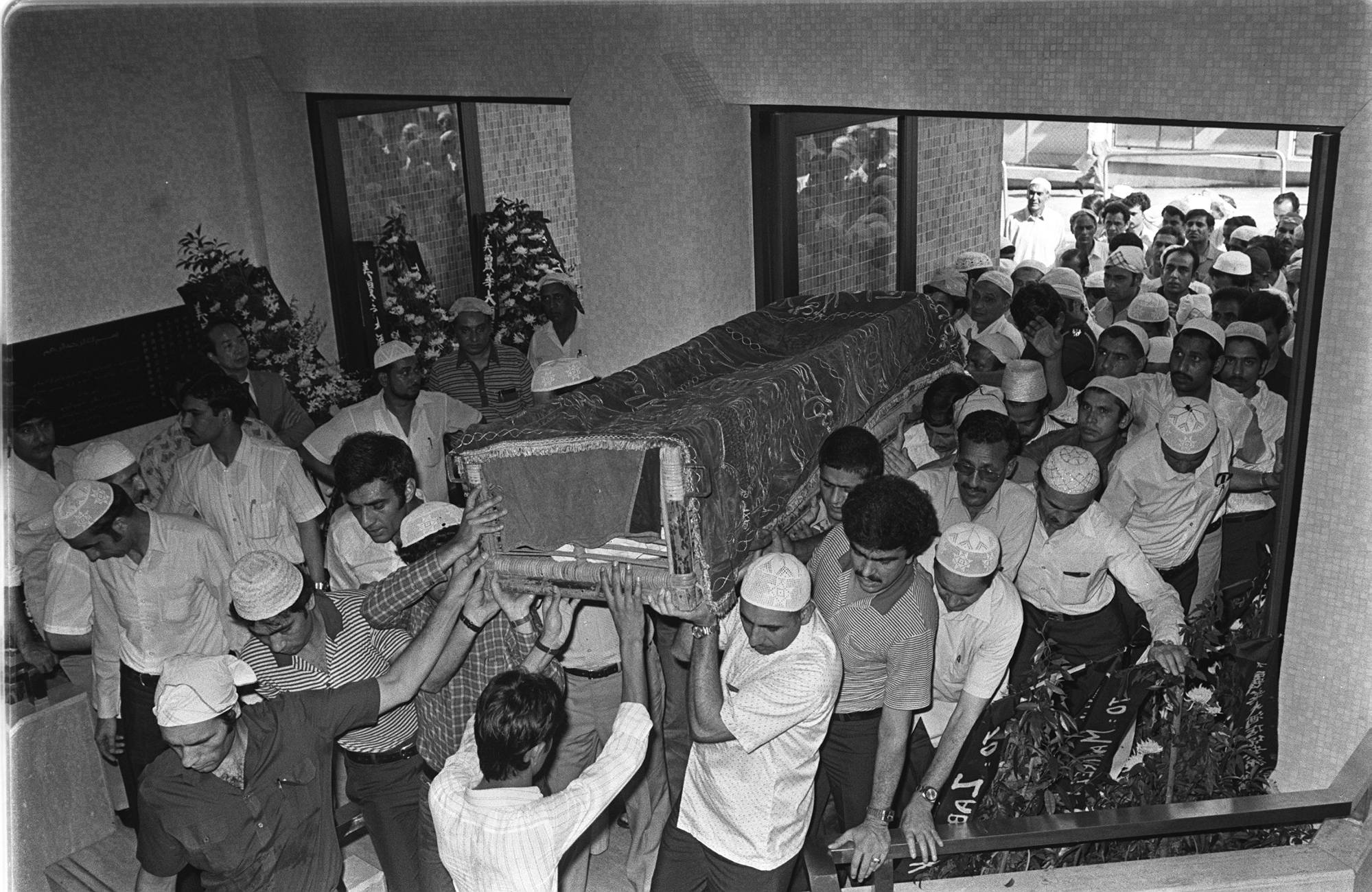 Mourners carry a casket at the funeral service for the two slain Pakistani security guards. Photo: SCMP