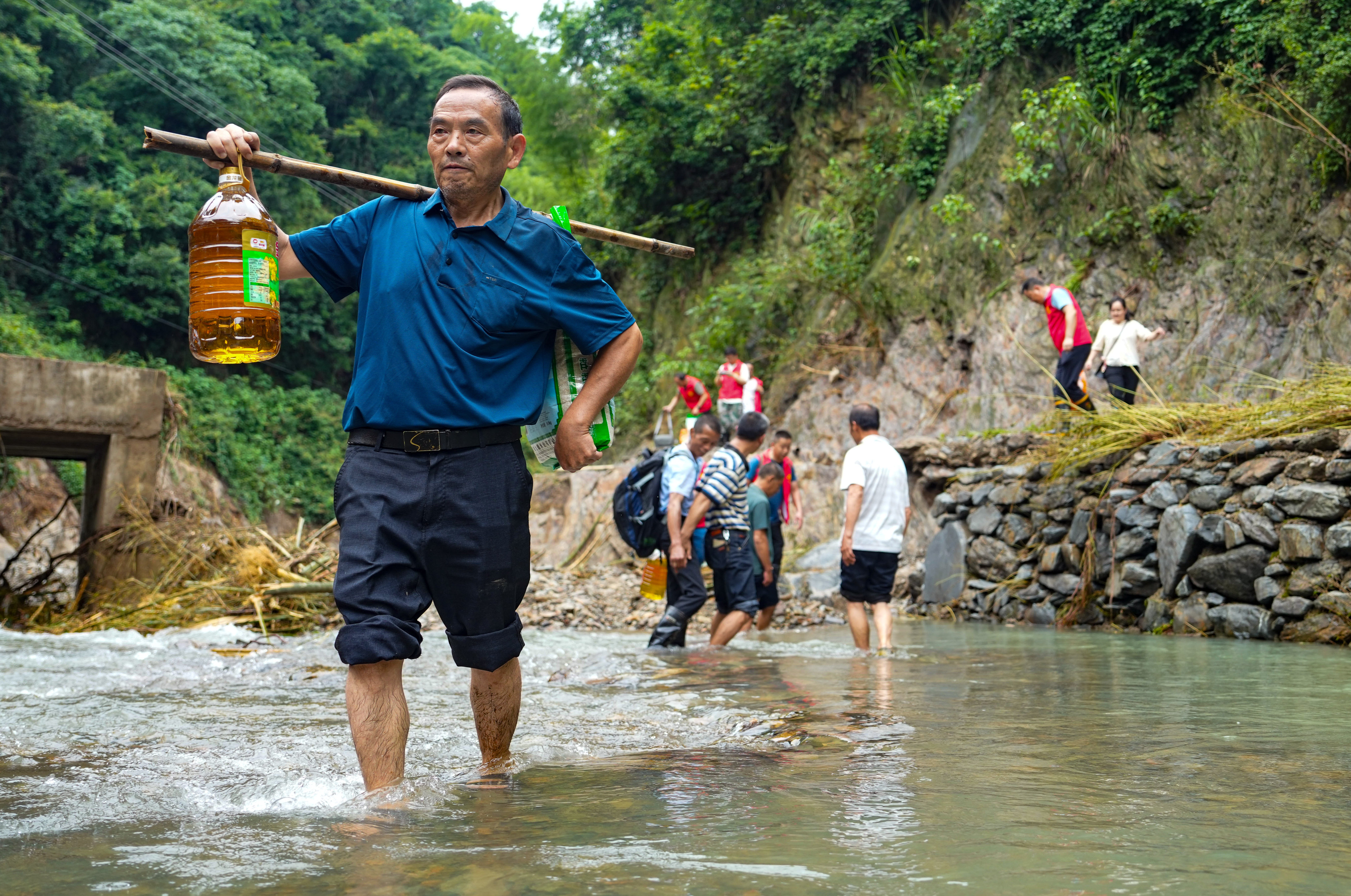 Volunteers from Yiwangxi in Hunan carry supplies to disaster victims. In 24 hours to 8am on Saturday,  a record 395.6mm rainfall in the area caused landslides and isolated residents. Photo: Xinhua