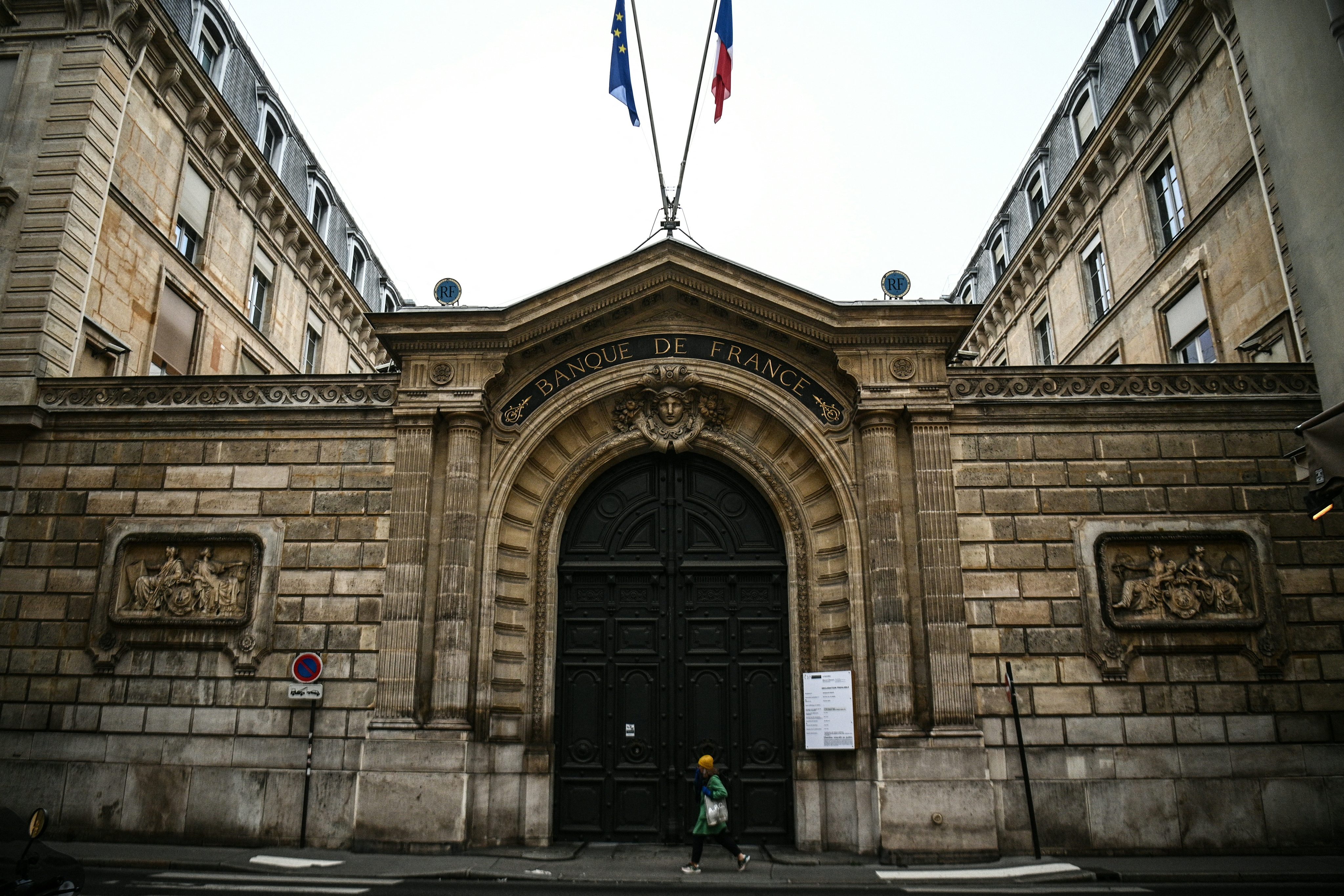 A photograph taken on December 6, 2022, shows a pedestrian walking past the main entrance of the Banque de France building in Paris. Photo: AFP