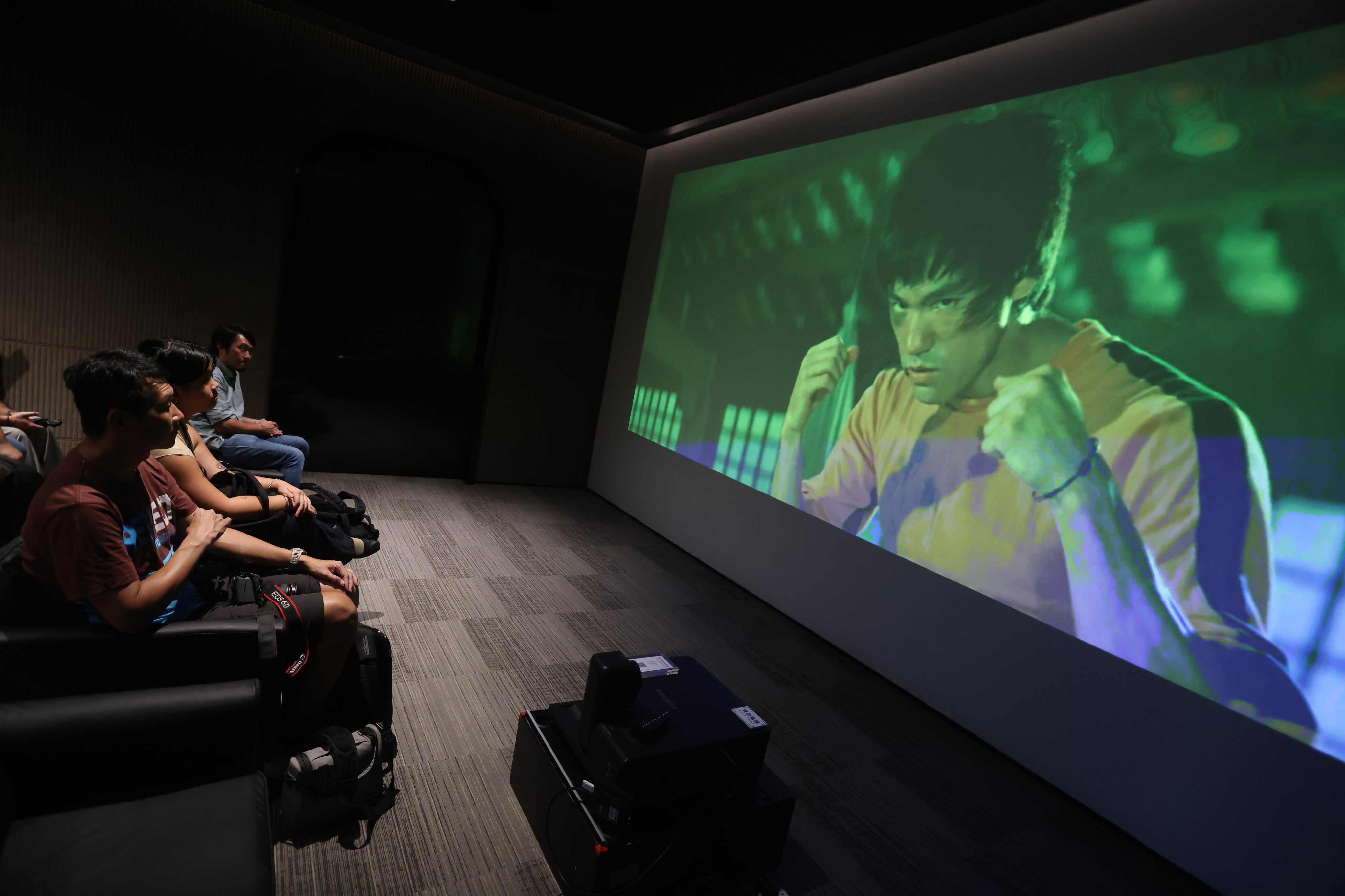 Visitors to a pop-up exhibition in Causeway Bay, Hong Kong, about Bruce Lee’s unfinished film Game of Death watch footage shot for the film. Photo: Jonathan Wong