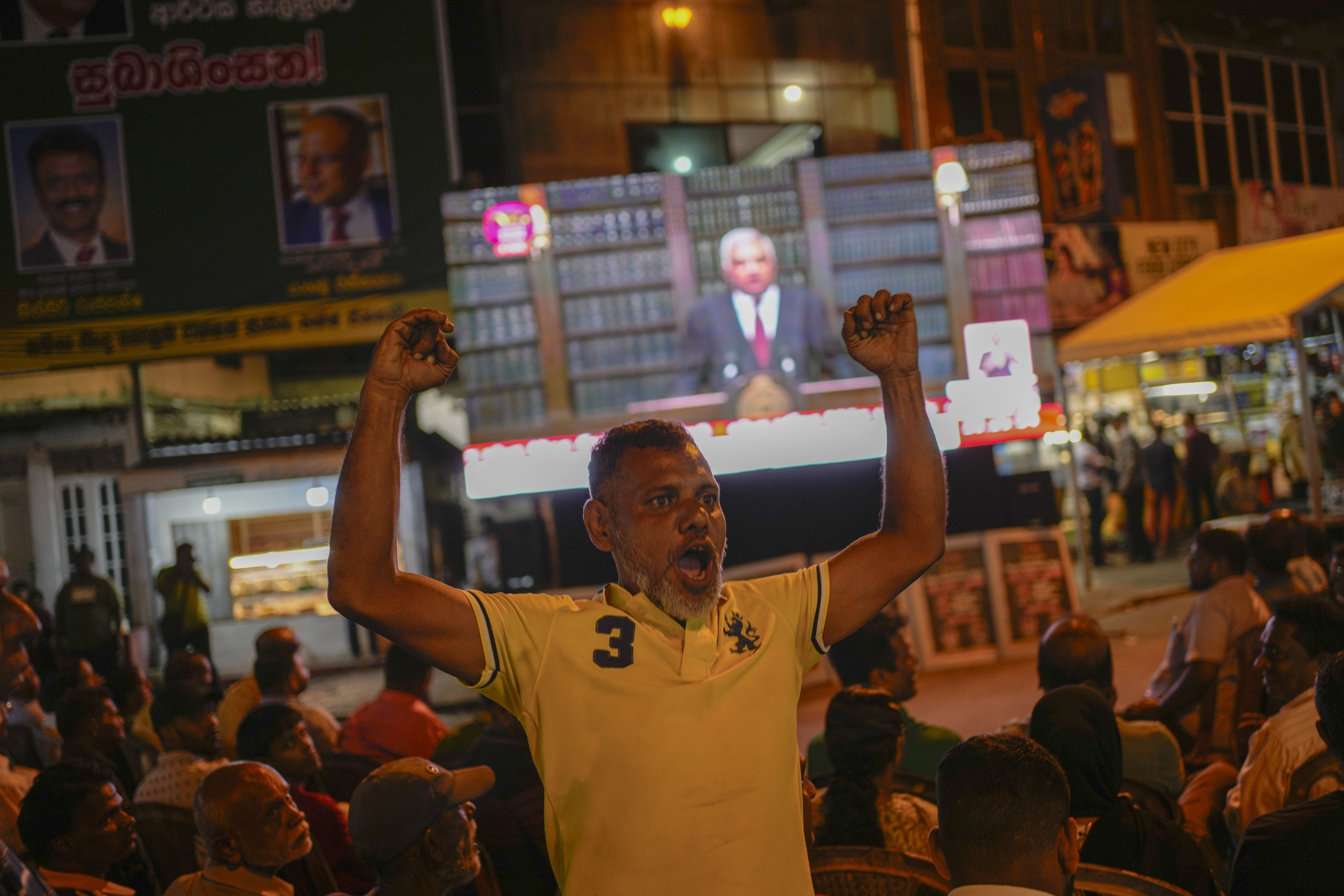 A supporter of Sri Lanka’s President Ranil Wickremesinghe cheers as he watches the president’s televised announcement of the country’s debt restructuring agreements on June 26. Photo: AP 