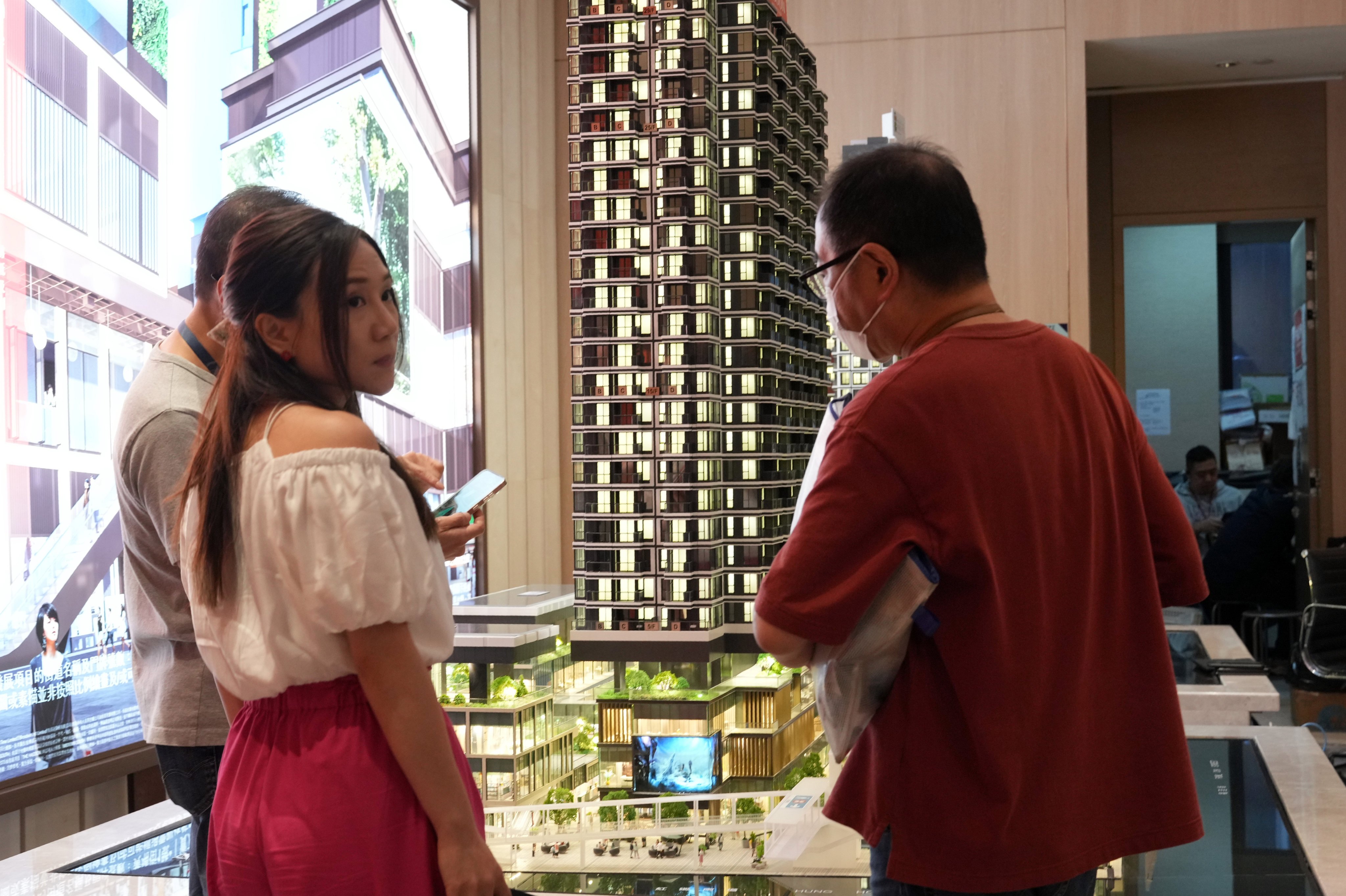 Potential buyers look at the models of the residential buildings at a property sales office in Hong Kong. Photo: May Tse