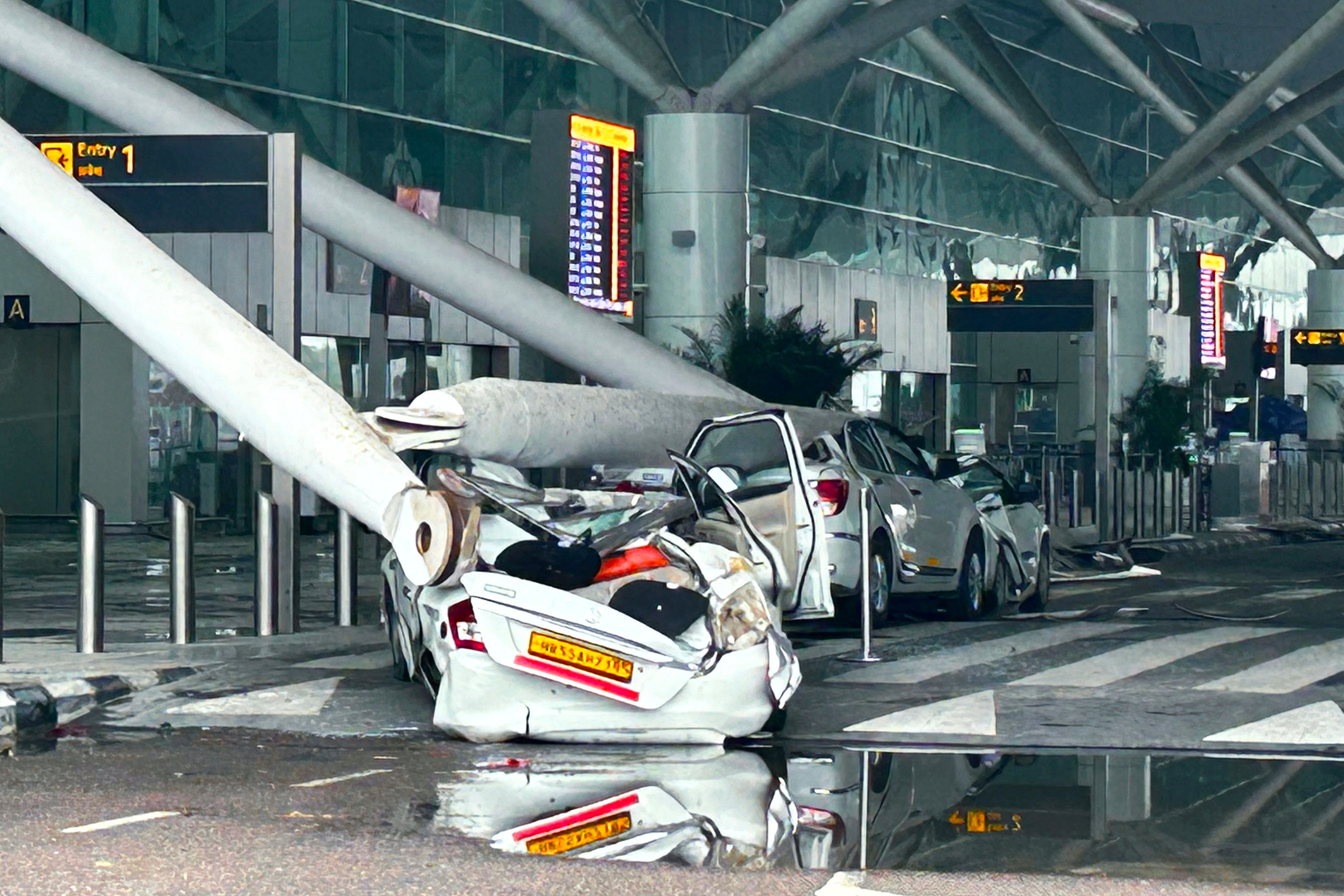 Parked vehicles were damaged by the collapse of a departure terminal canopy at New Delhi airport on Friday. Photo: AP