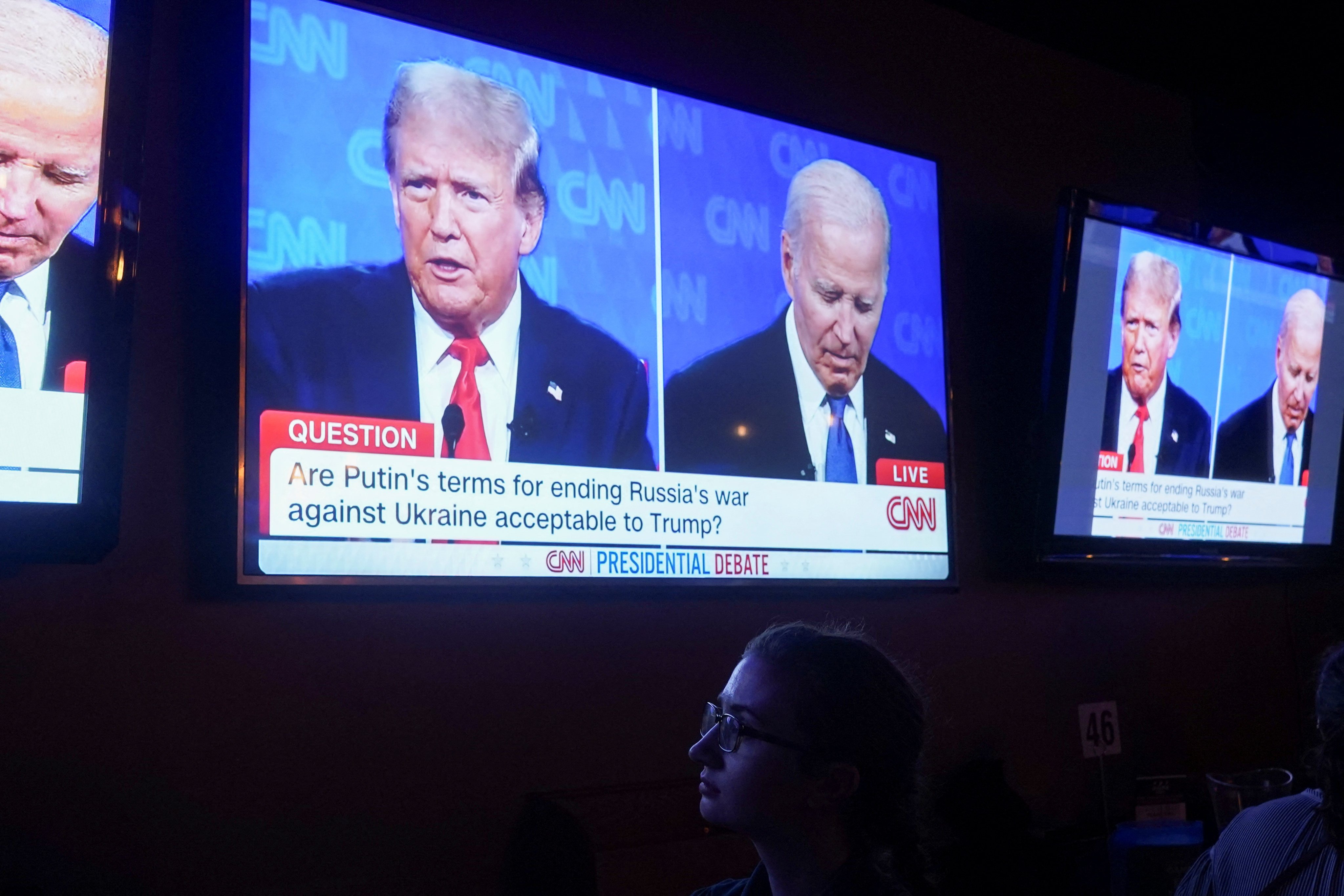 TV screens showing US President Joe Biden and  Donald Trump during a watch party in Washington. Photo: Reuters