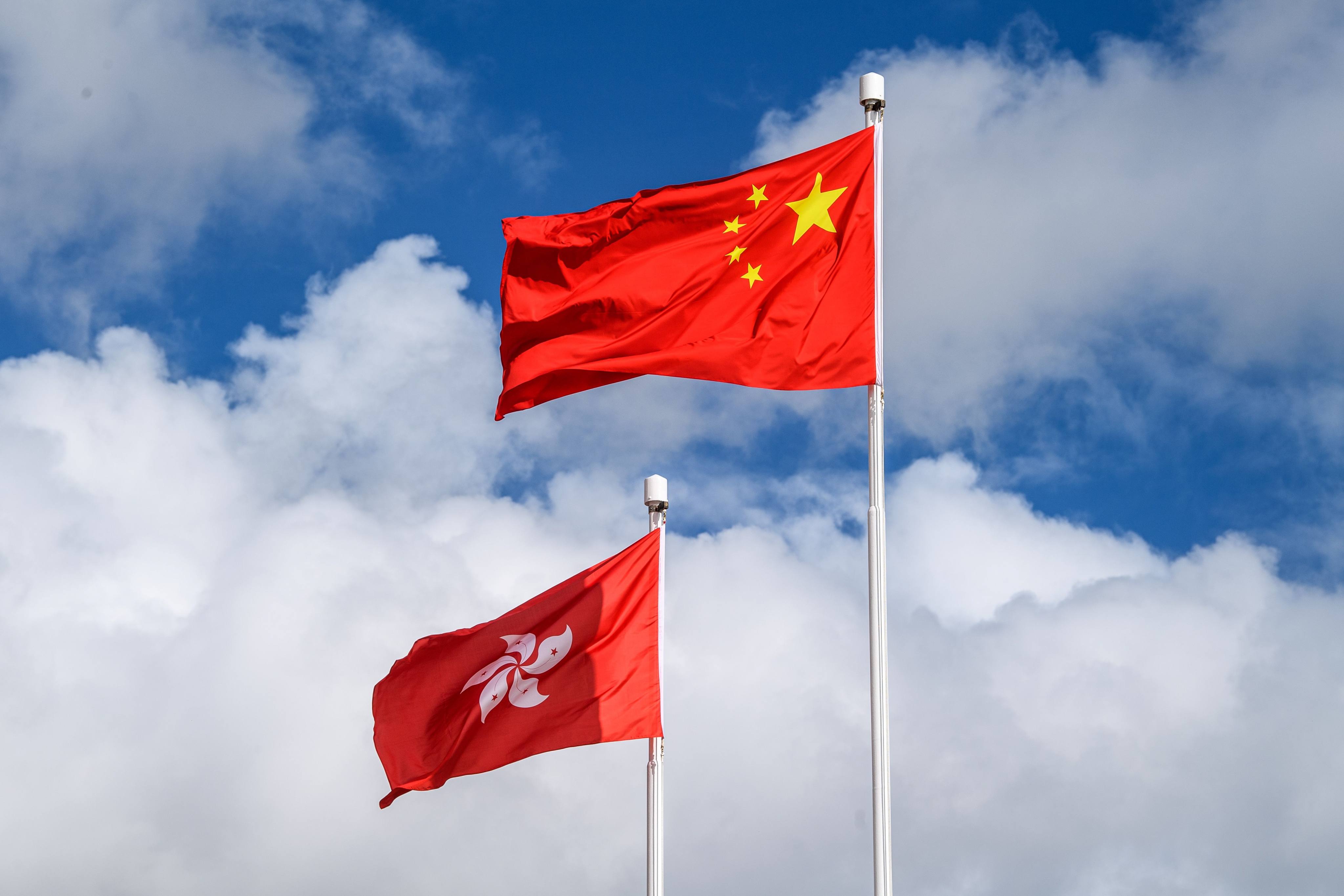 The Chinese (R) and Hong Kong (L) flags are seen hoisted at the end of a flag-raising ceremony to mark the 23rd anniversary of Hong Kong’s handover from Britain in Hong Kong on July 1, 2020. - Hong Kong marked the 23rd anniversary of its handover to China on July 1 under the glare of a new national security law imposed by Beijing, with protests banned and the city’s cherished freedoms looking increasingly fragile. (Photo by Anthony WALLACE / AFP)