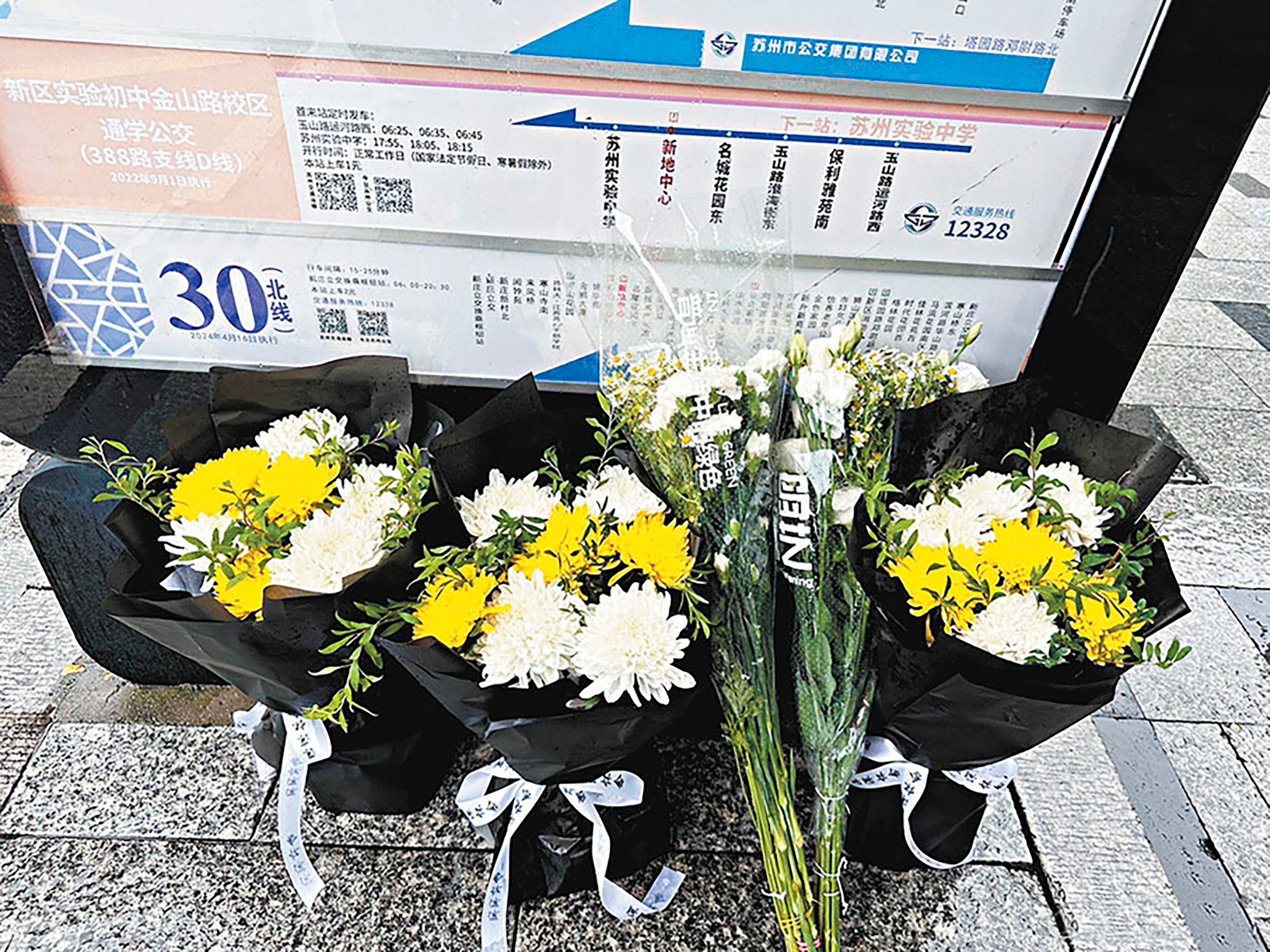 Flowers lay in tribute in Suzhou to school bus attendant Hu Youping died on Wednesday from wounds she sustained trying to subdue a knife-wielding attacker at a bus stop. Photo: Weibo