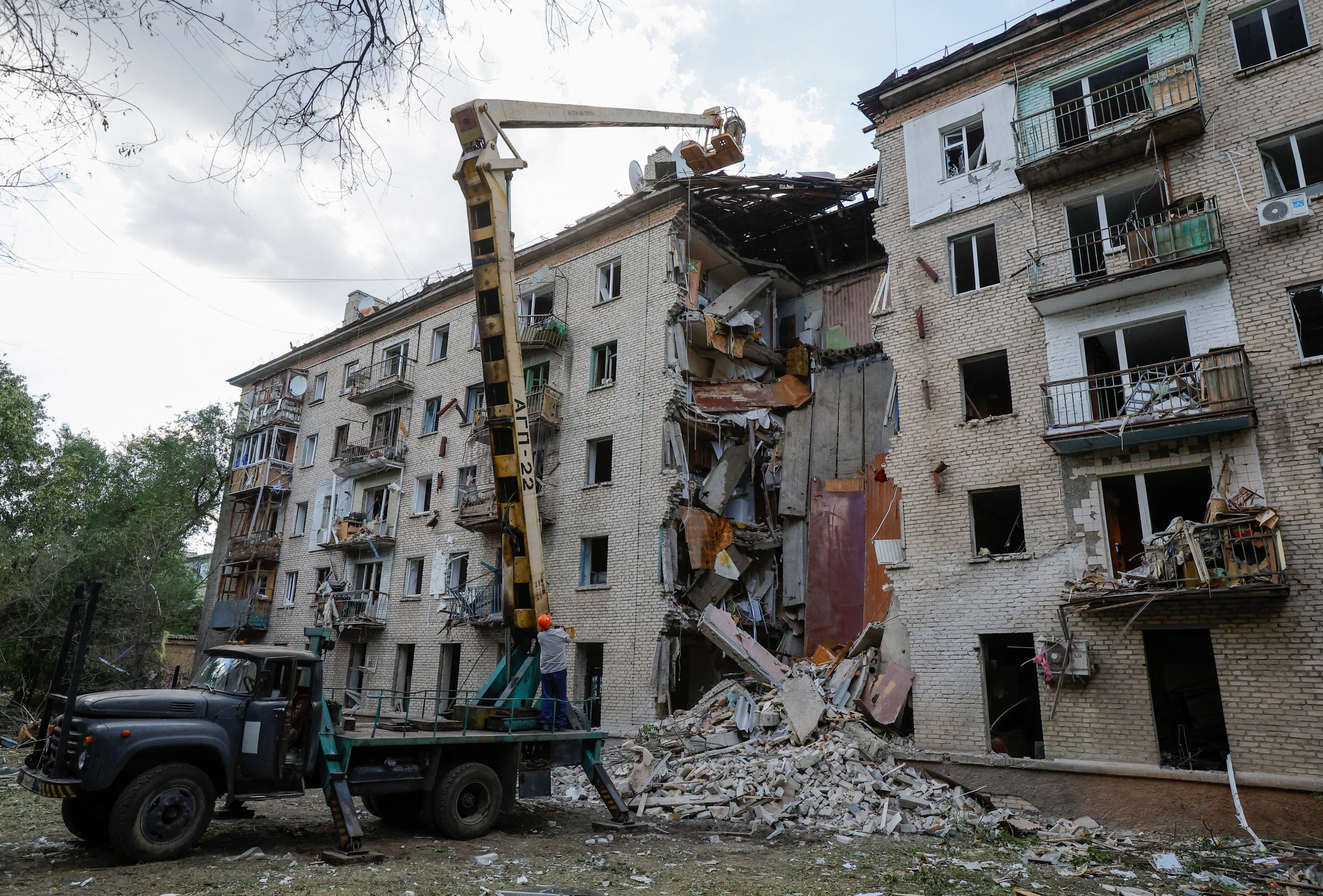 Emergency specialists work at a residential building damaged in Ukrainian shelling in Luhansk on June 7. Photo: Reuters

