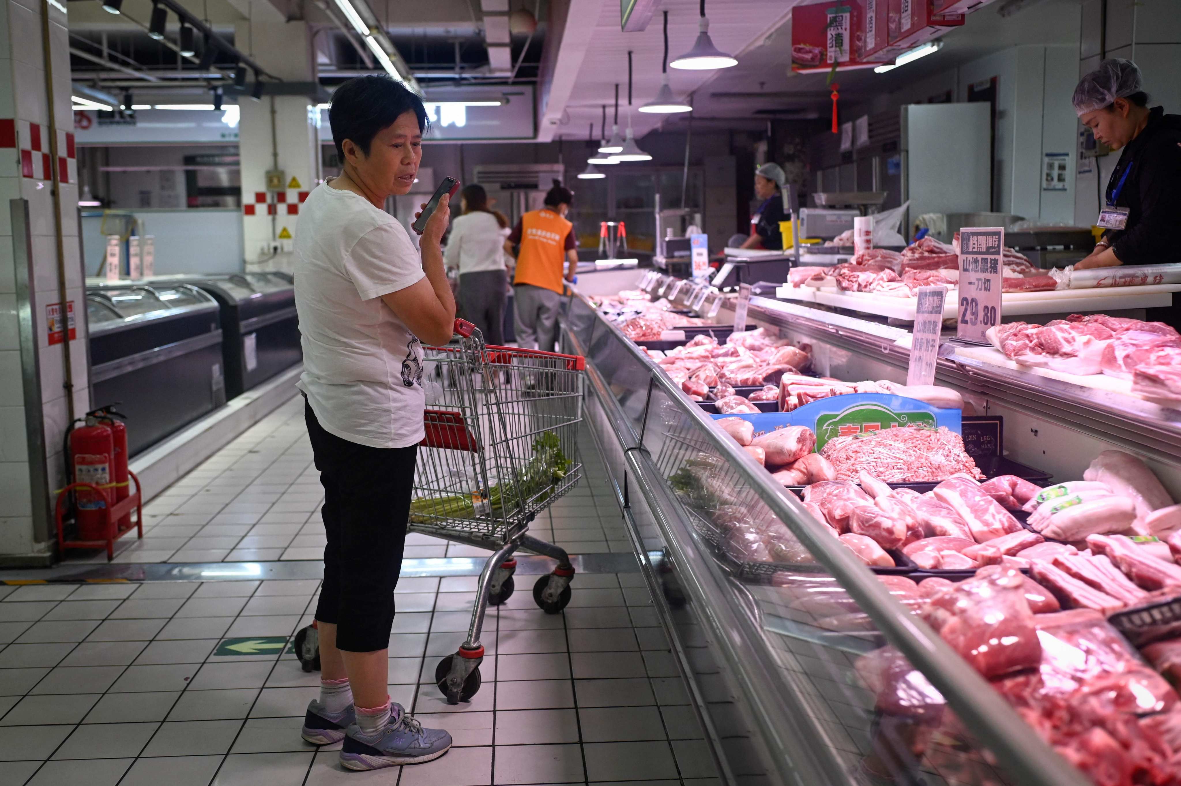 A woman selects pork products at a supermarket in Beijing. Photo: AFP