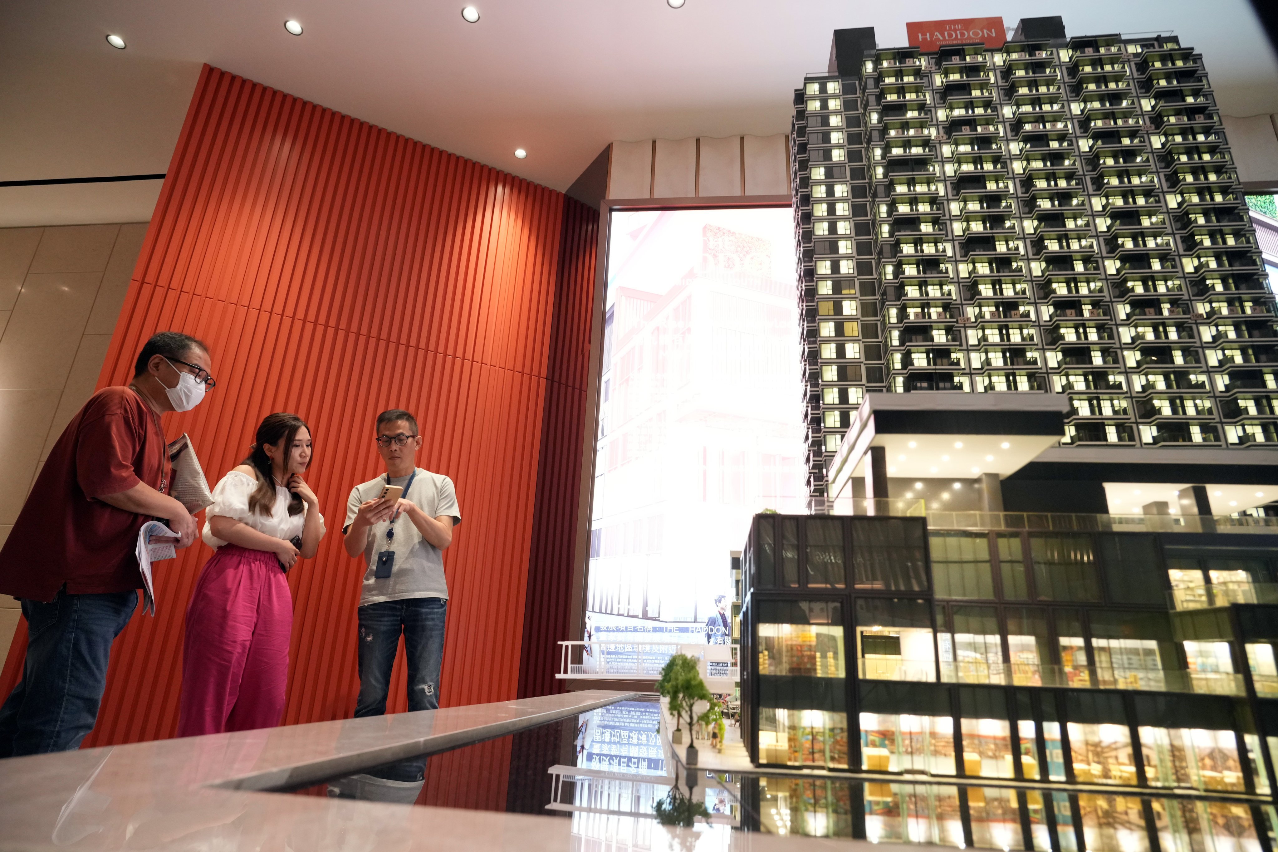 Potential buyers look at a model showing Henderson Land’s Hung Hom residential project The Haddon at a property sales office in Tsim Sha Tsui, Hong Kong, on June 11, 2024. Photo: May Tse