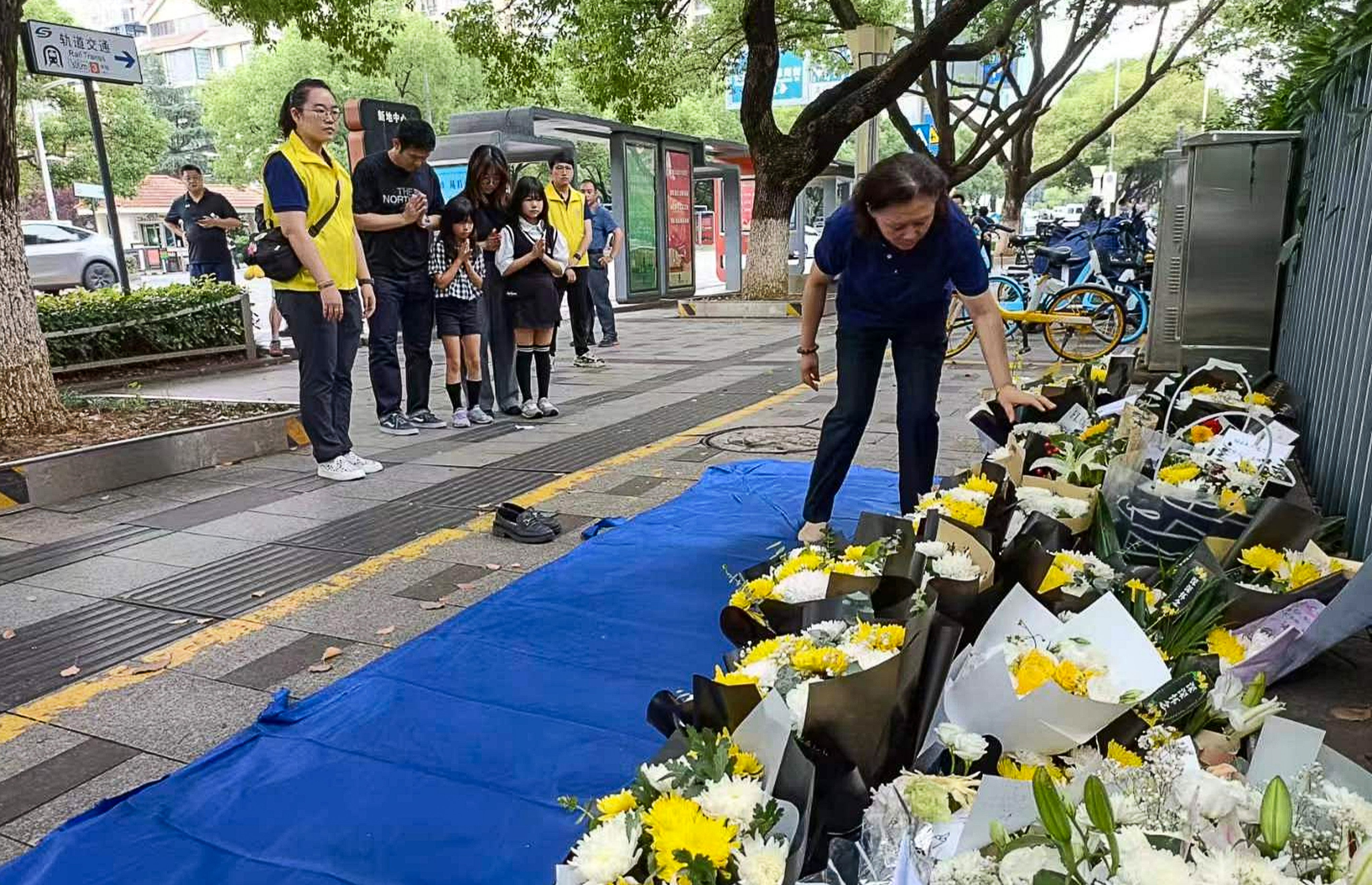 Members of the public leave tributes to Hu Youping near the scene of the attack. Photo: Weibo/ 袁一陀