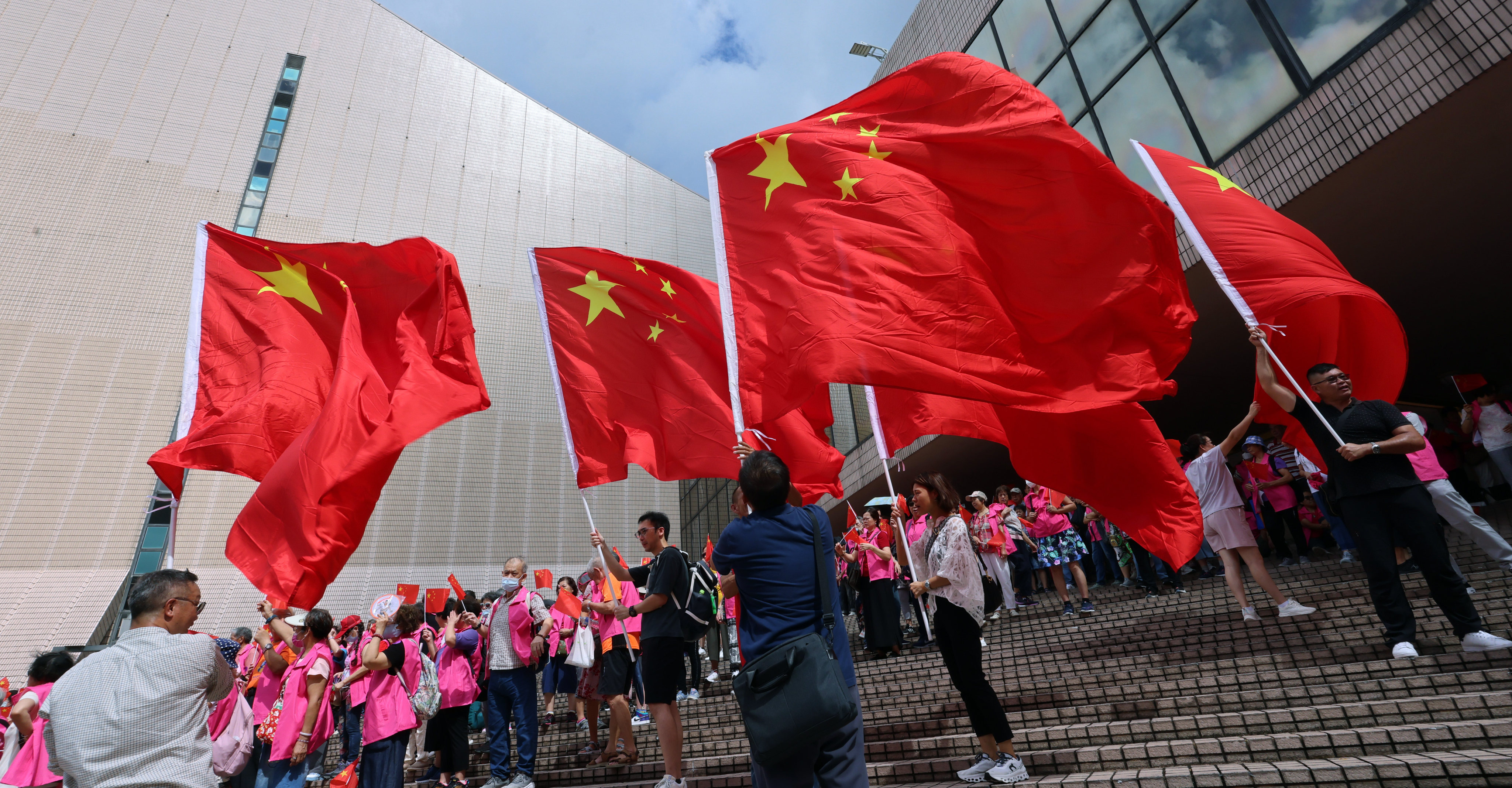 People hold regional and national flags outside the Cultural Centre in Tsim Sha Tsui to celebrate the 27th anniversary of the handover of Hong Kong. Photo: Jelly Tse