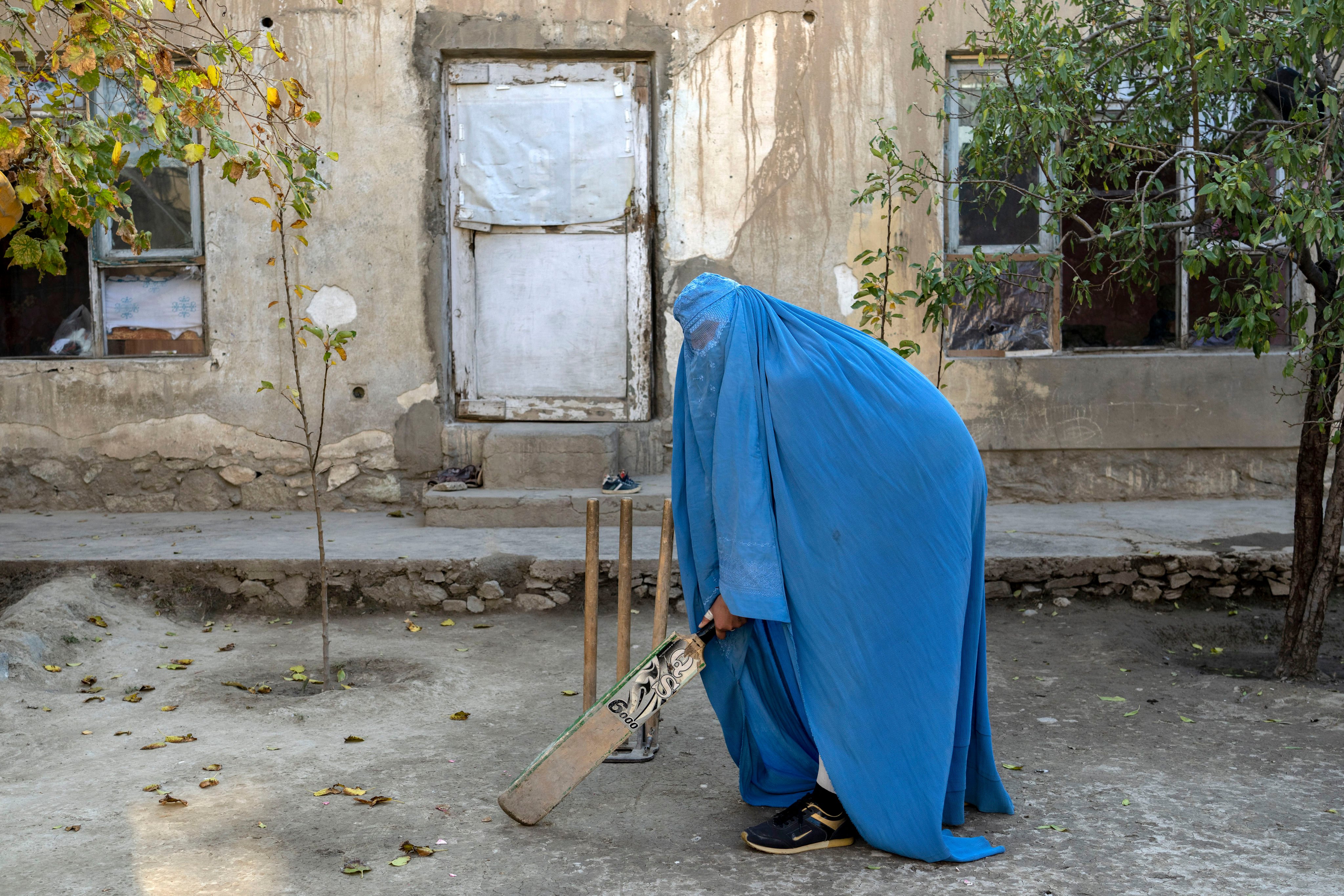An Afghan woman posing with her cricket bat in Kabul, Afghanistan in 2022. The ruling Taliban have banned women from competitive sports as well as most schooling and many realms of work. Photo: AP