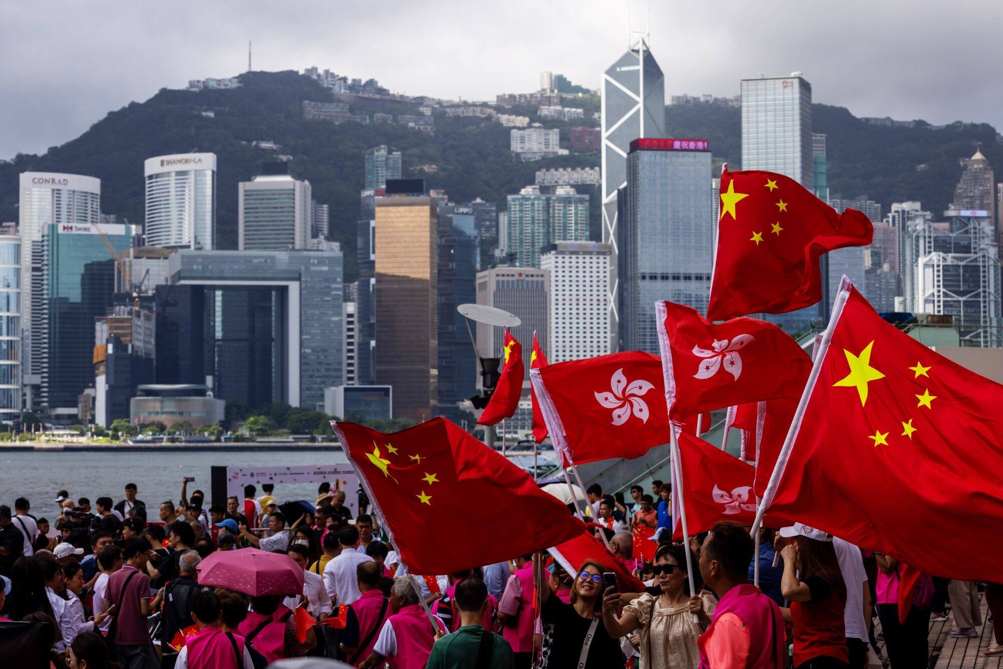 People wave the flags of China and Hong Kong during an event celebrating the 27th anniversary of Hong Kong’s return to Chinese rule in Hong Kong on July 1. Photo: Bloomberg