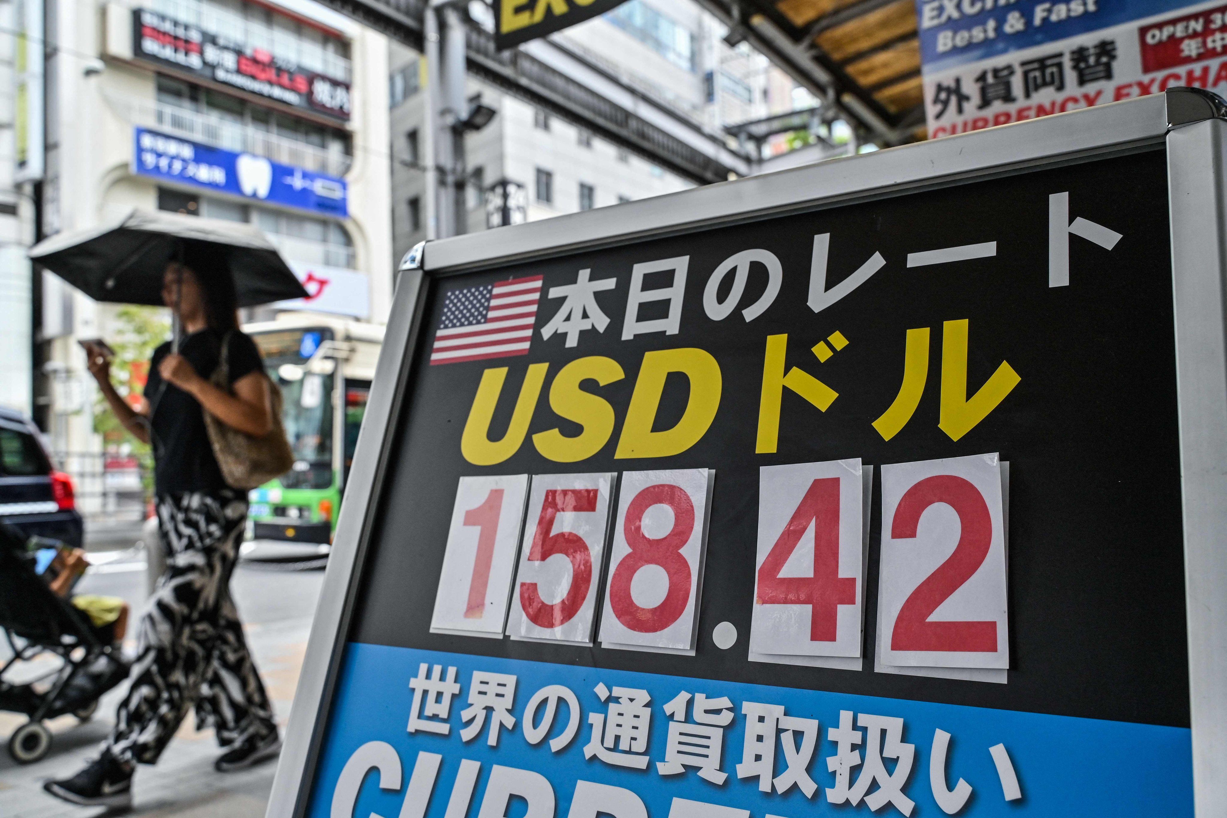 A woman walks past a currency exchange shop in central Tokyo on June 30, after the yen slid to its weakest value against the US dollar since 1986. It’s time to end the weak-yen policy, which has over the years deadened the urgency for Tokyo to raise its economic game and increase competitiveness. Photo: AFP