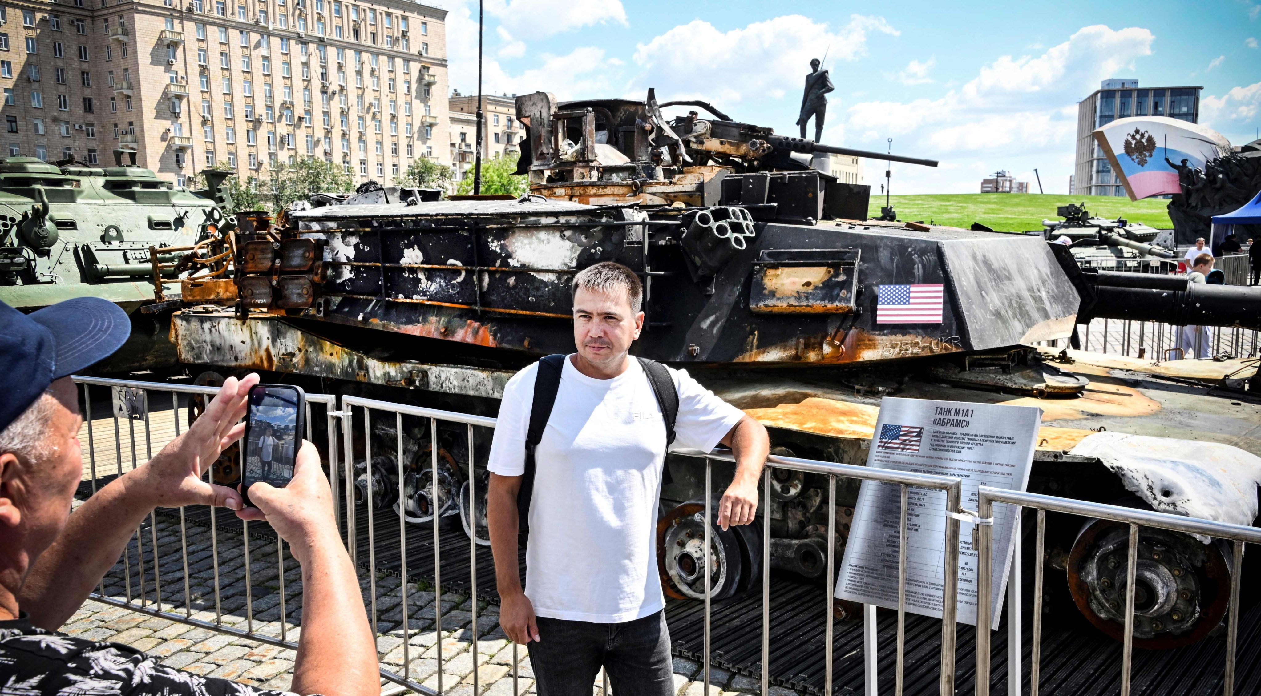 People pose in front of a US tank captured by Russian forces in Ukraine, displayed at a war memorial complex in western Moscow on June 27. Photo: AFP