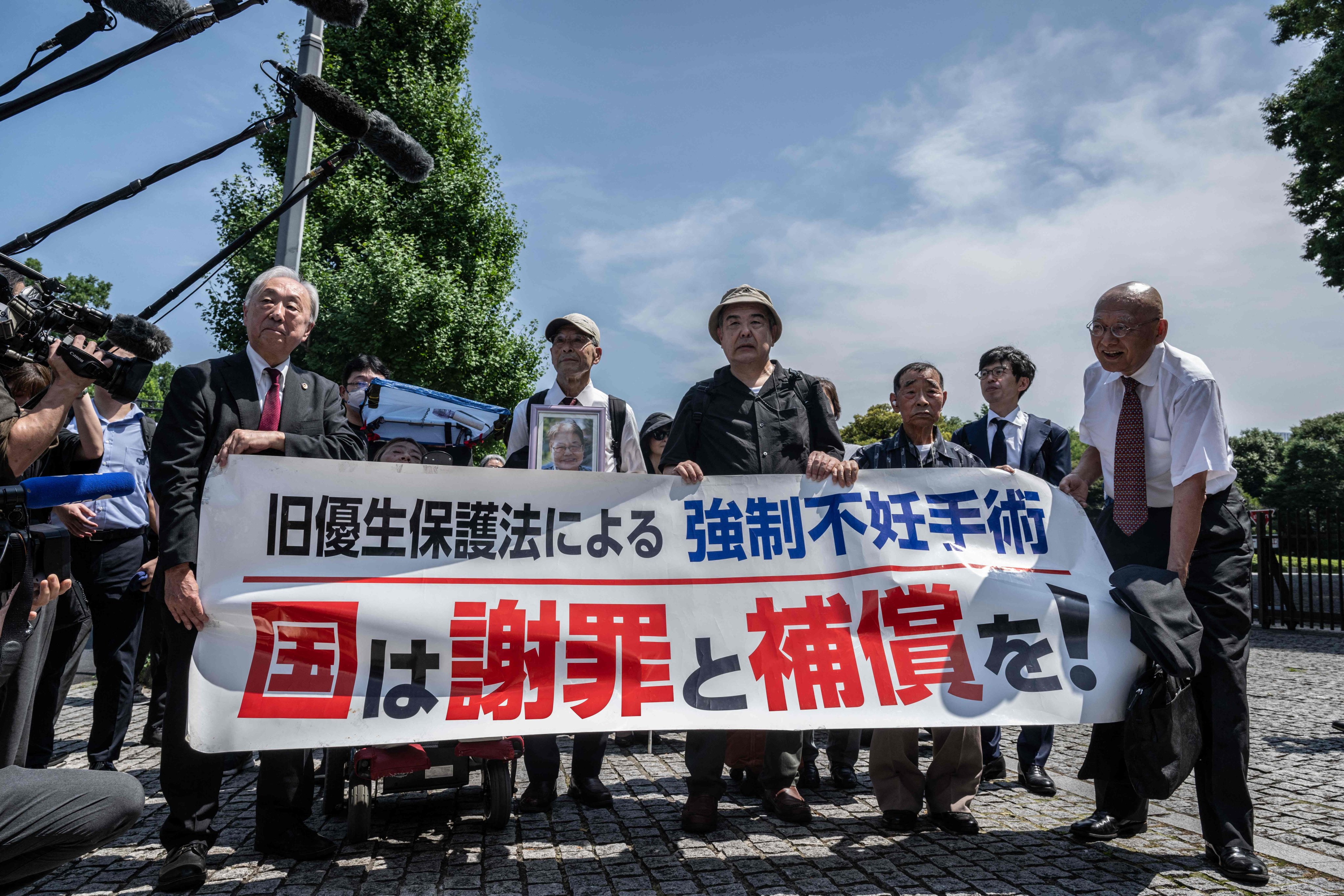 Lawyers and supporters of victims of forced sterilisation under a now-defunct eugenics law, carry a banner demanding apologies and compensations in Tokyo on Wednesday. Photo: AFP