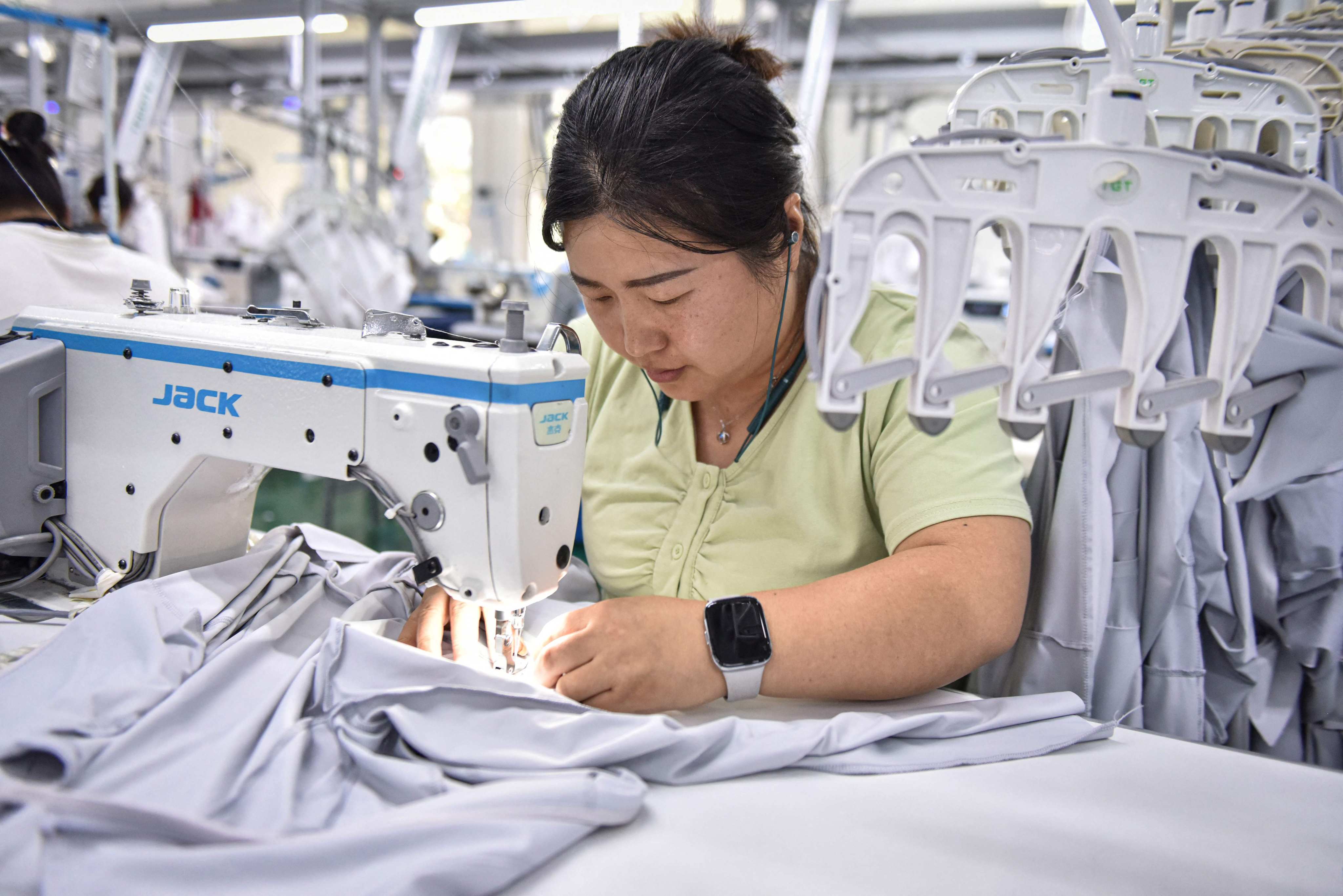 An employee working on sun protection clothing at a factory in Fuyang. Photo: AFP