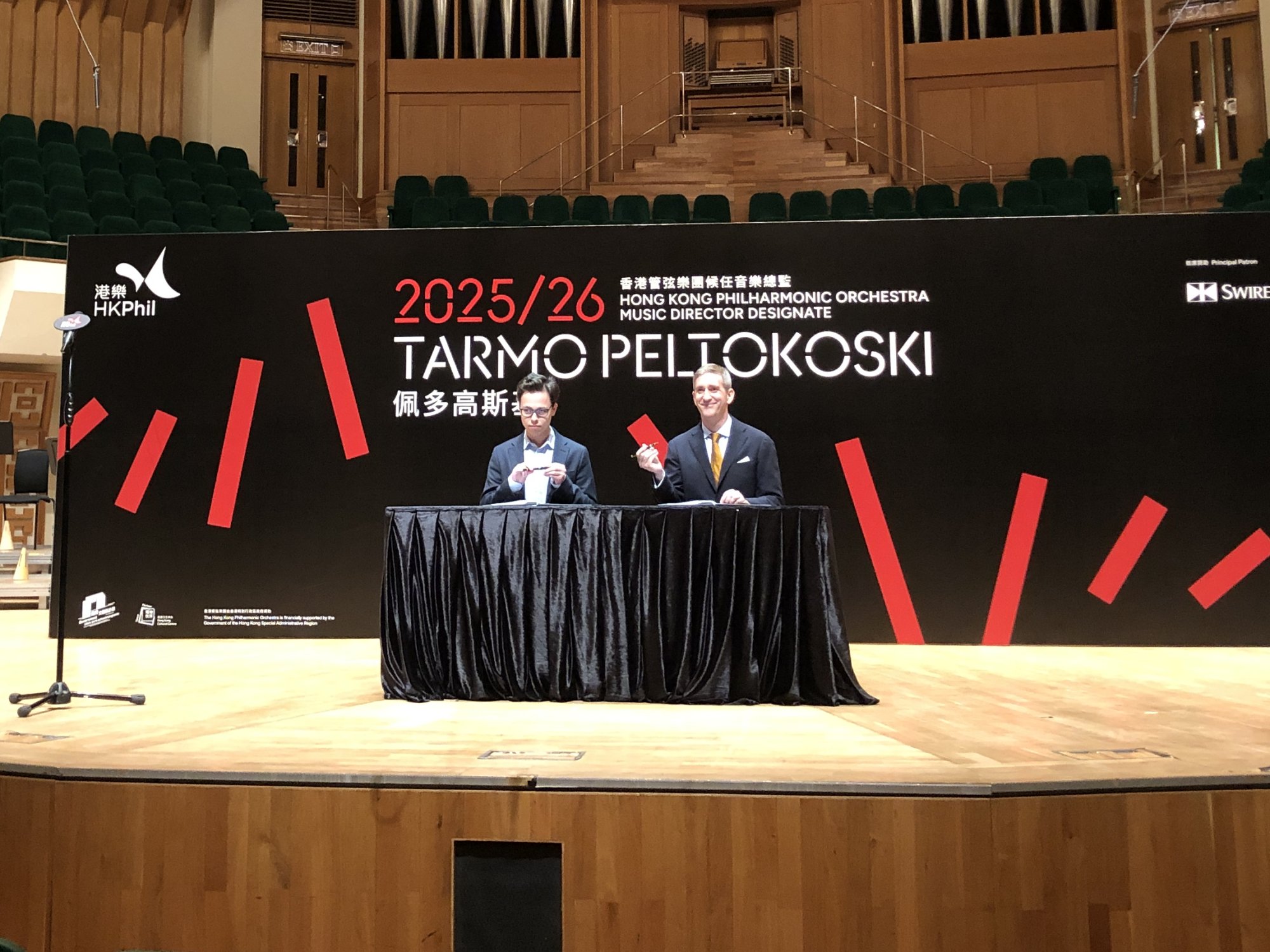 Peltokoski (left) and David Cogman, chairman of the board of the HK Phil, sign the contract that makes Peltokoski music director designate. Photo: Enid Tsui