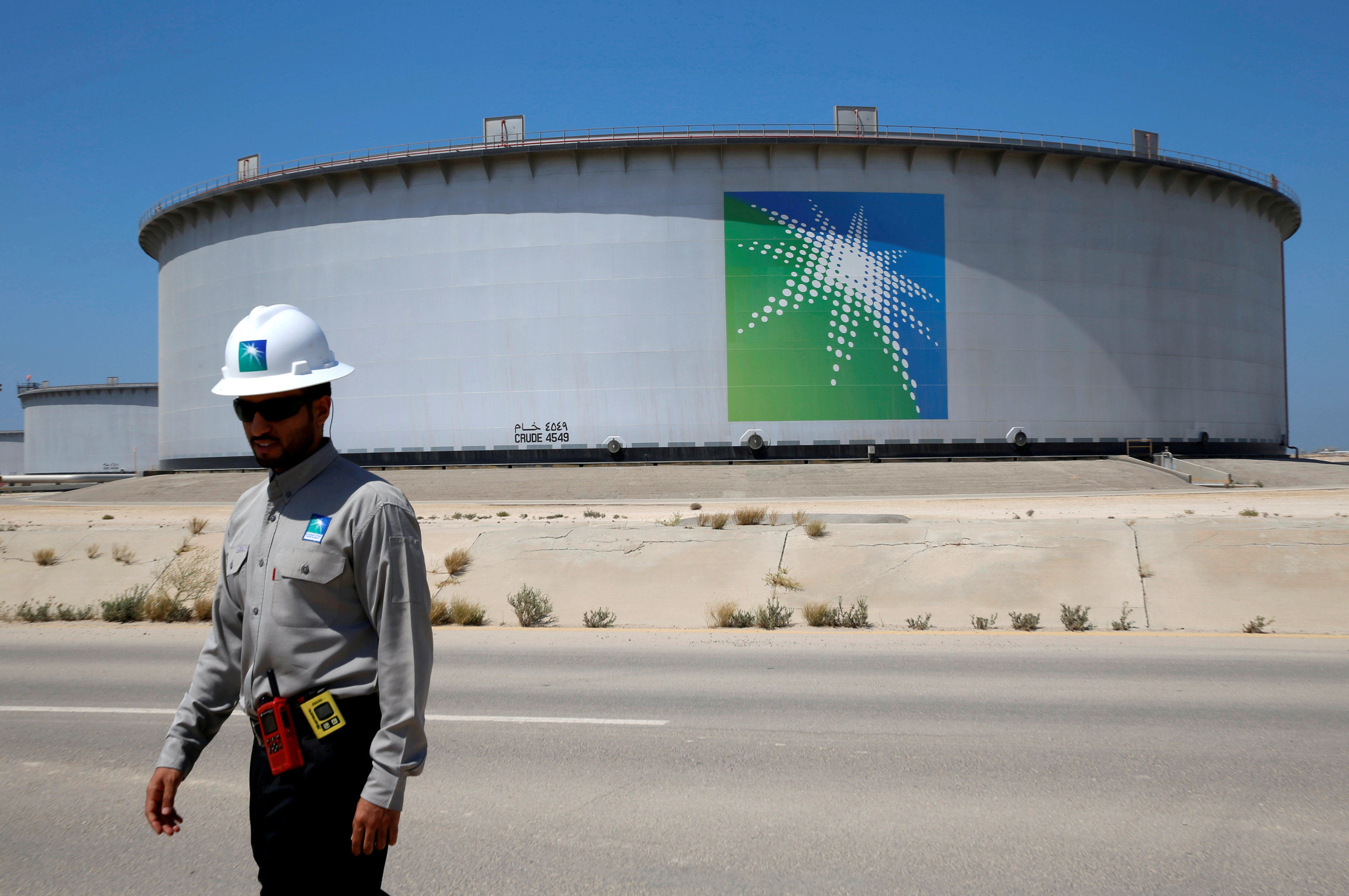 An Aramco employee walks near an oil tank at Saudi Aramco’s Ras Tanura oil refinery and oil terminal in Saudi Arabia May 21, 2018. Photo: Reuters