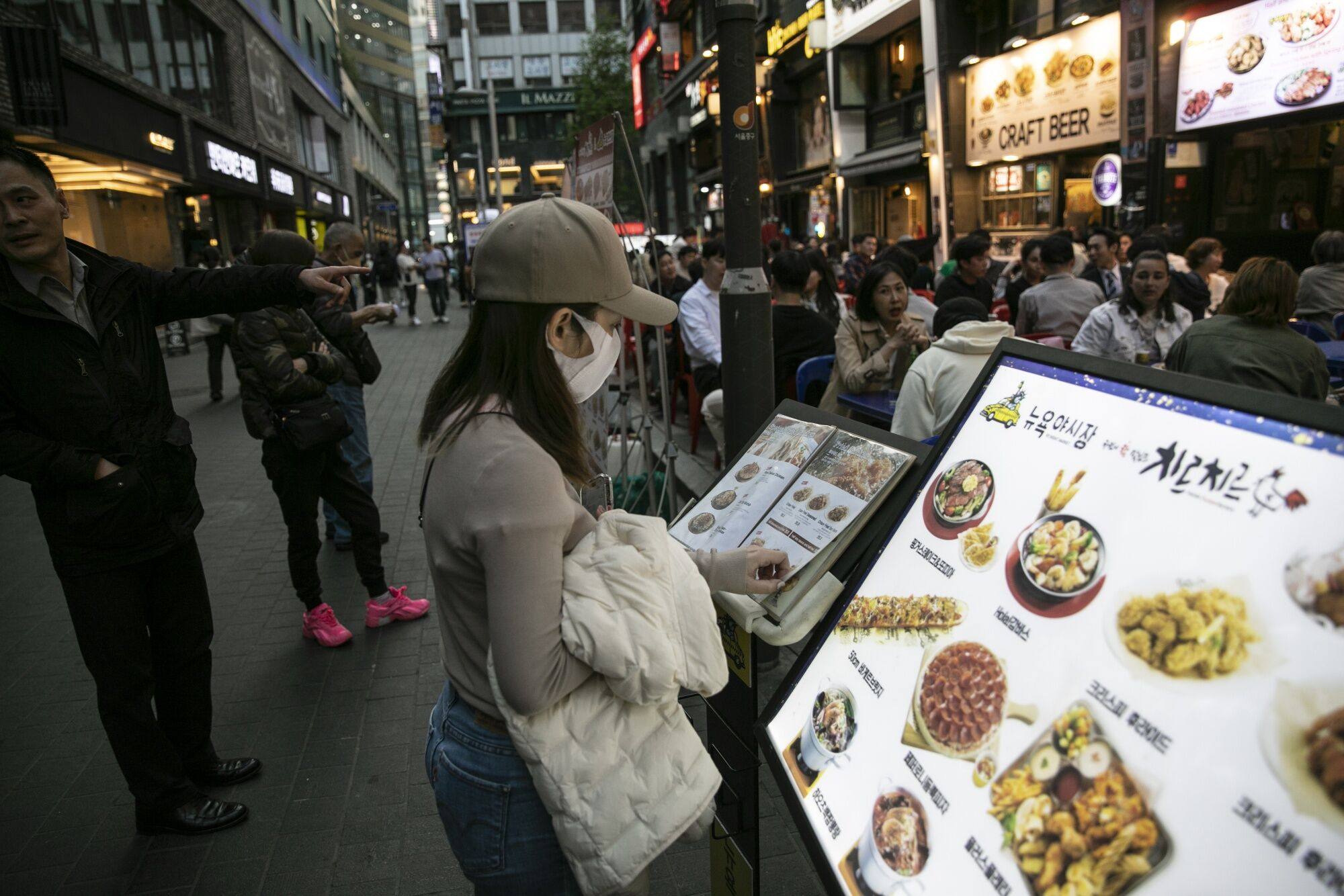 A customer outside a restaurant in Seoul’s Myeongdong shopping district. The Deloitte report showed that south Koreans’ conspicuous consumption in the food and beverage sector is about three to four times higher compared to spending on household items. Photo: Bloomberg