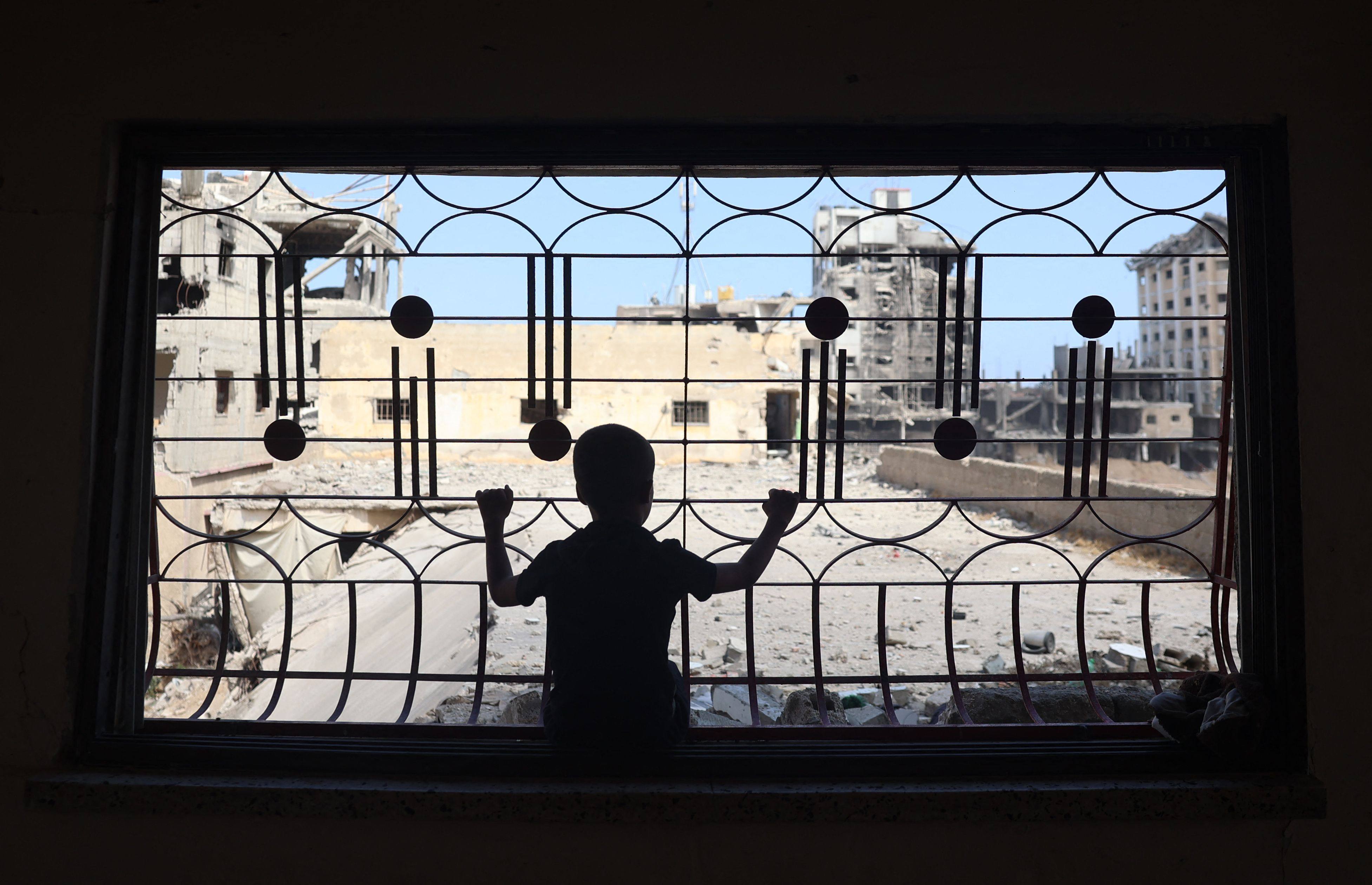 A Palestinian child looks out from the window of a home damaged from previous Israeli bombardment, as residents return to the city of Khan Younis, in the southern Gaza Strip, on Sunday. Photo: AFP