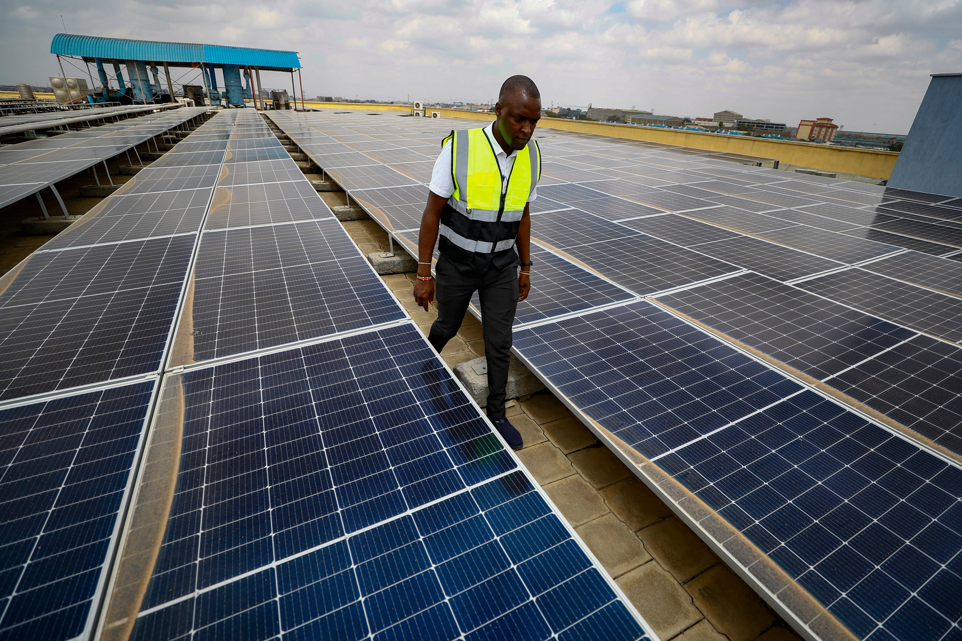 A technician examines solar panels on the roof of a company in Nairobi, Kenya, on September 1, 2023. In South Africa and Kenya, where outages are common, solar energy is being used to power major businesses. Photo: AP