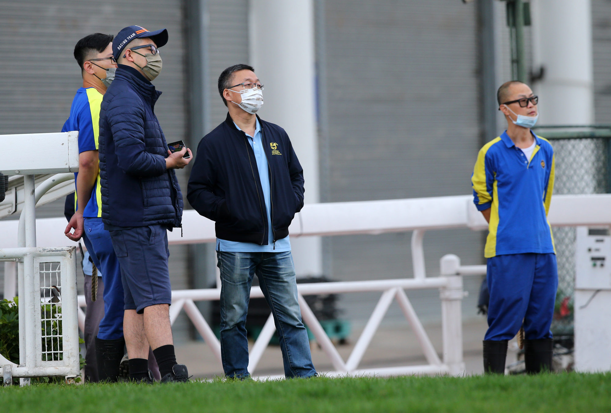 Francis Lui (second to right) and his then assistant trainer Pierre Ng (second to left) watch trackwork in 2021.