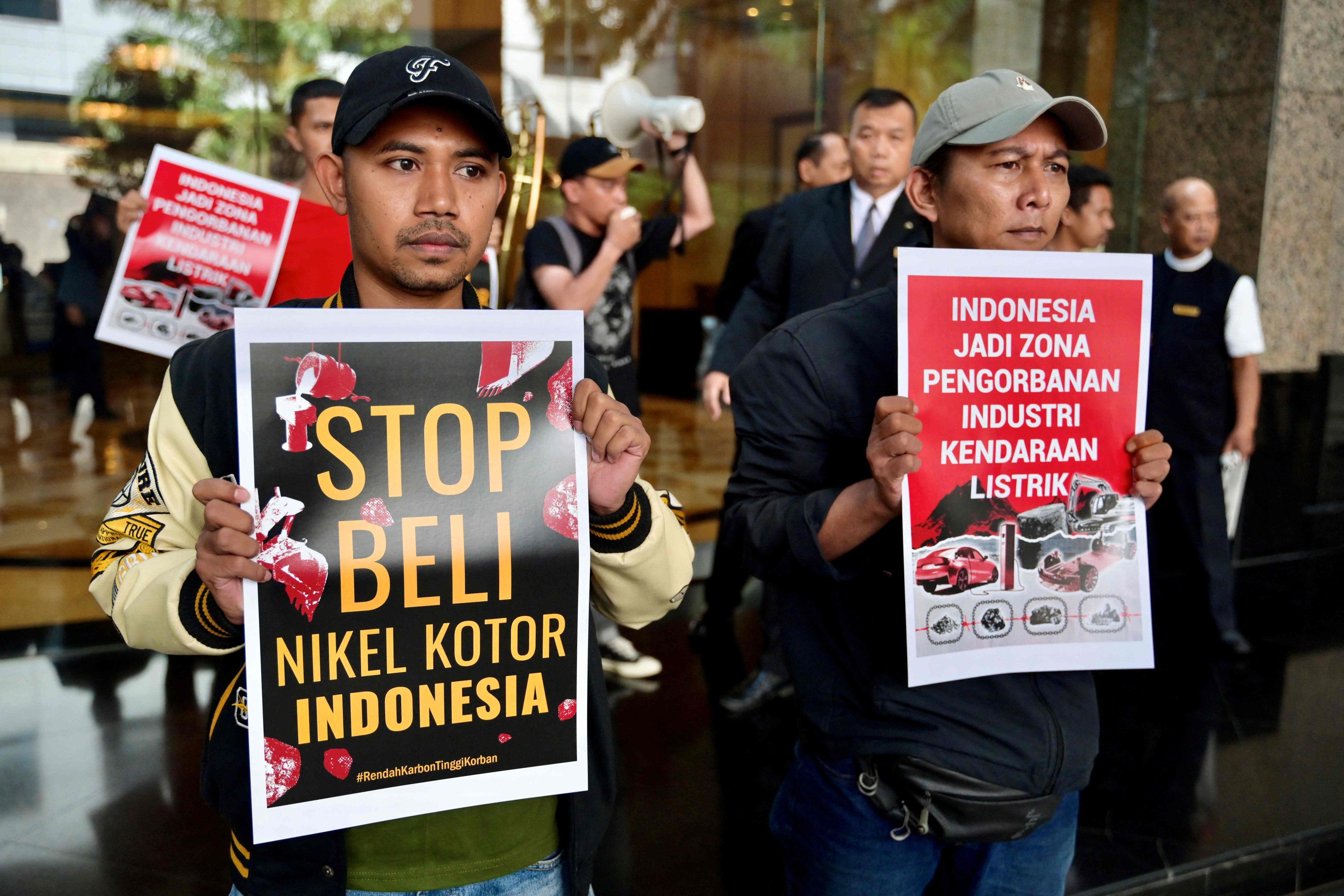 Environmental activists hold posters that say “stop buying Indonesia’s dirty nickel” and “Indonesia has become a sacrifice zone for the electric vehicle industry”, at a critical minerals conference venue in Jakarta. Photo: AFP