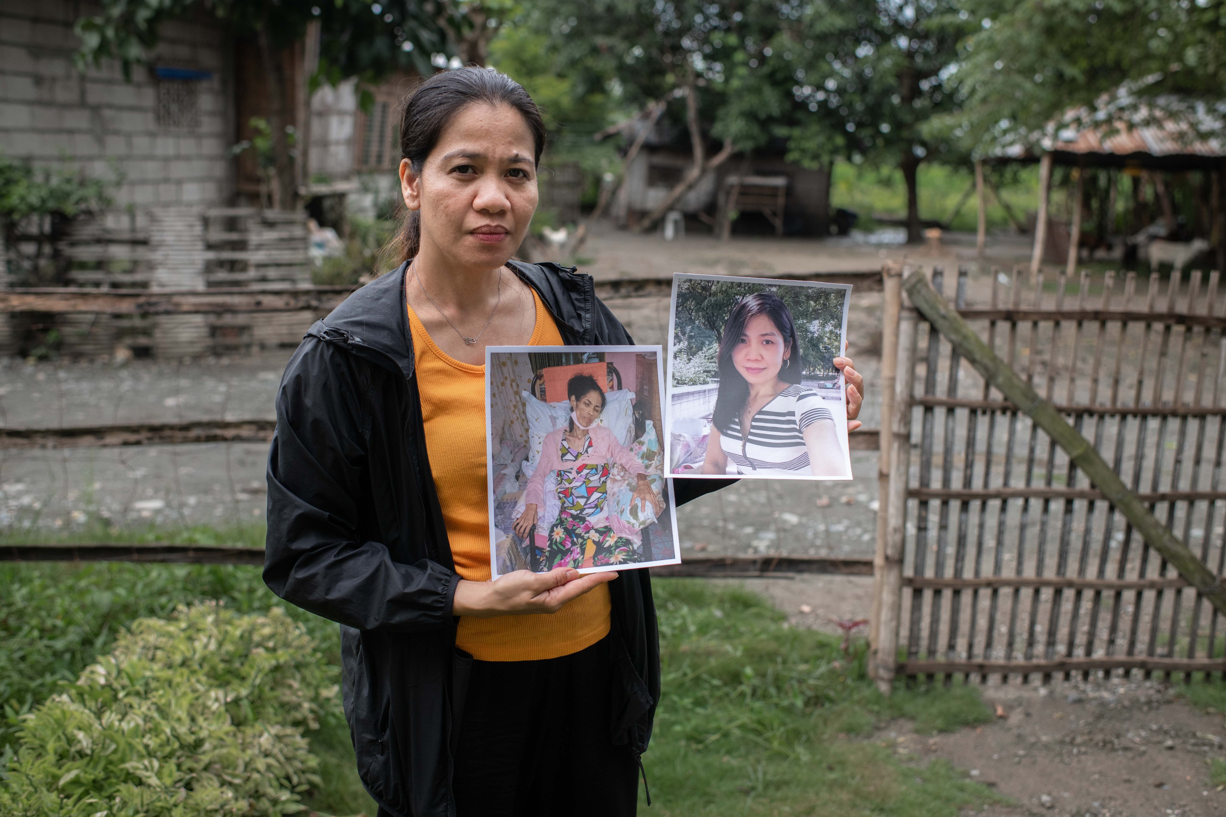 Carla Temporosa holds up pictures of her late friend Joan Guting in front of the latter’s house in Philippines in 2019. Photo: Handout