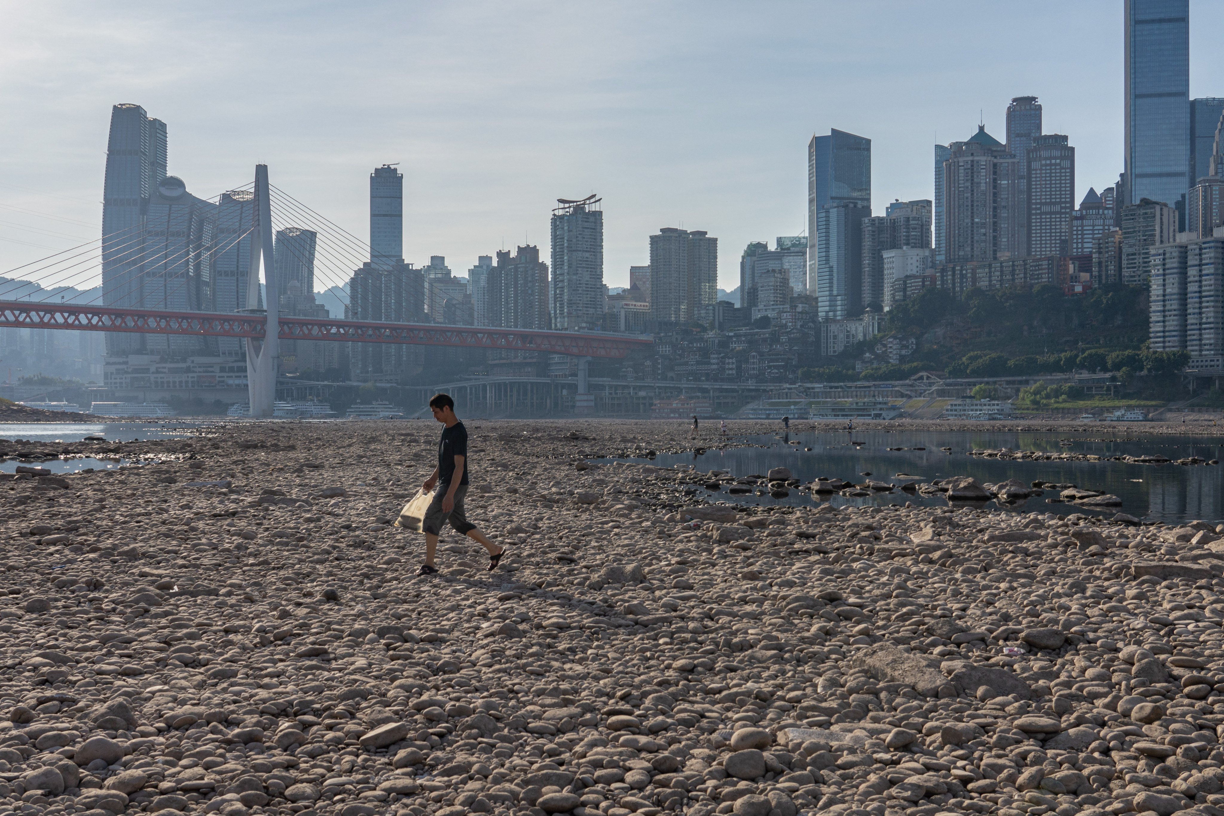 A man walked on the dried out riverbed of the Jialing River, a major tributary of the Yangtze River, in Chongqing on 21 August 2022. Photo: EPA-EFE