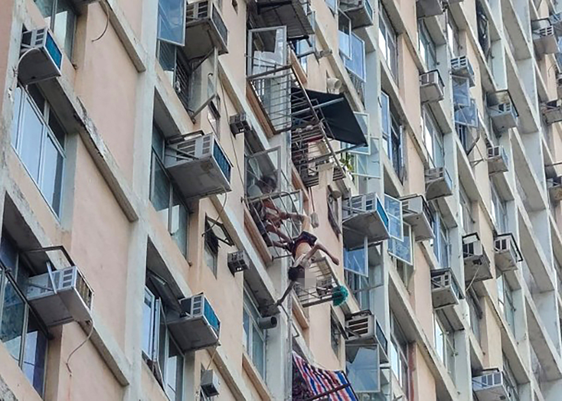 A 77-year-old man hung from his foot after falling while hanging laundry in Tsui Ping North Estate, Kwun Tong. Photo: Handout