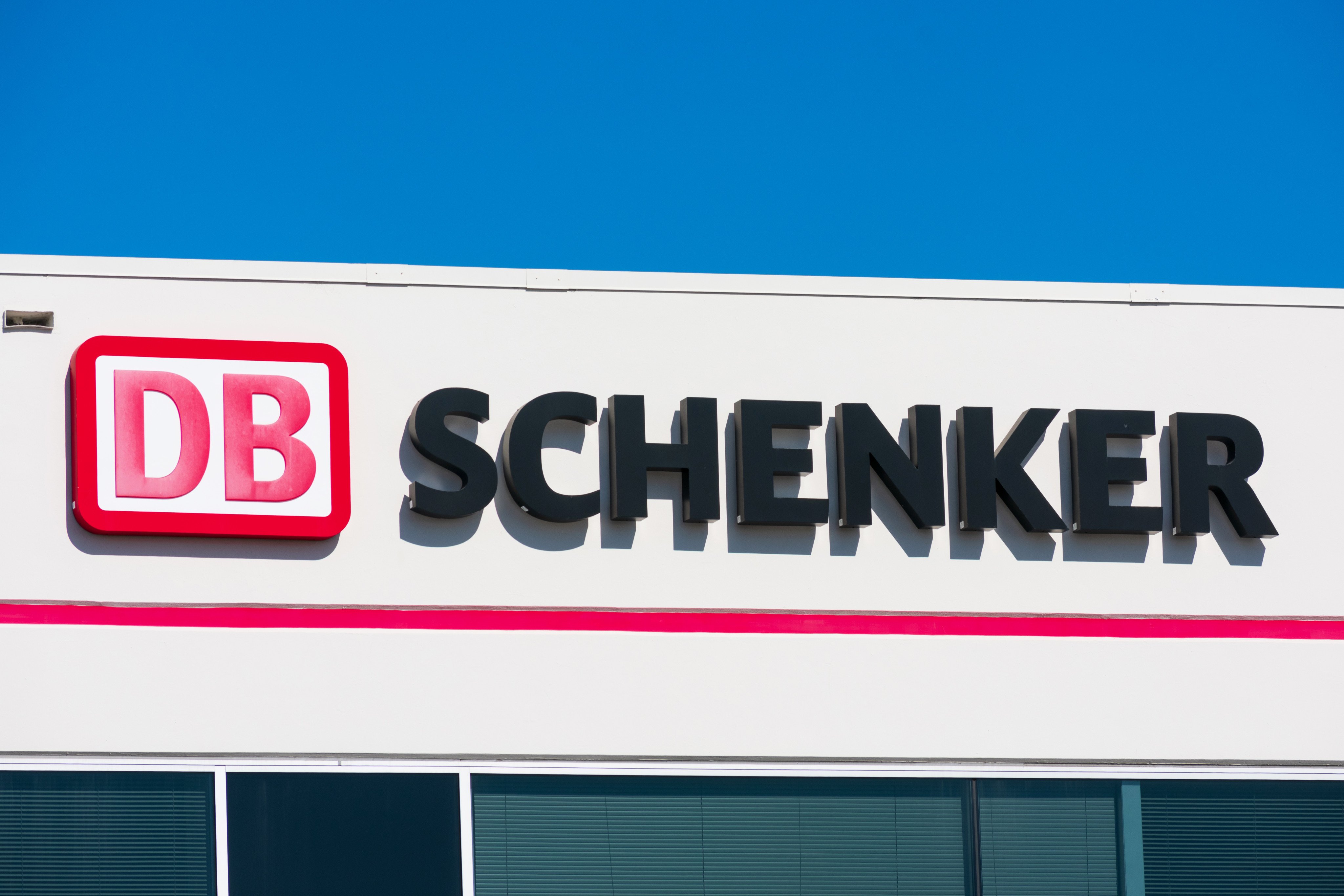 DB Schenker sign on transportation service office. DB Schenker is a division of the German rail operator Deutsche Bahn AG that focuses on logistics  Photo: Shutterstock Images