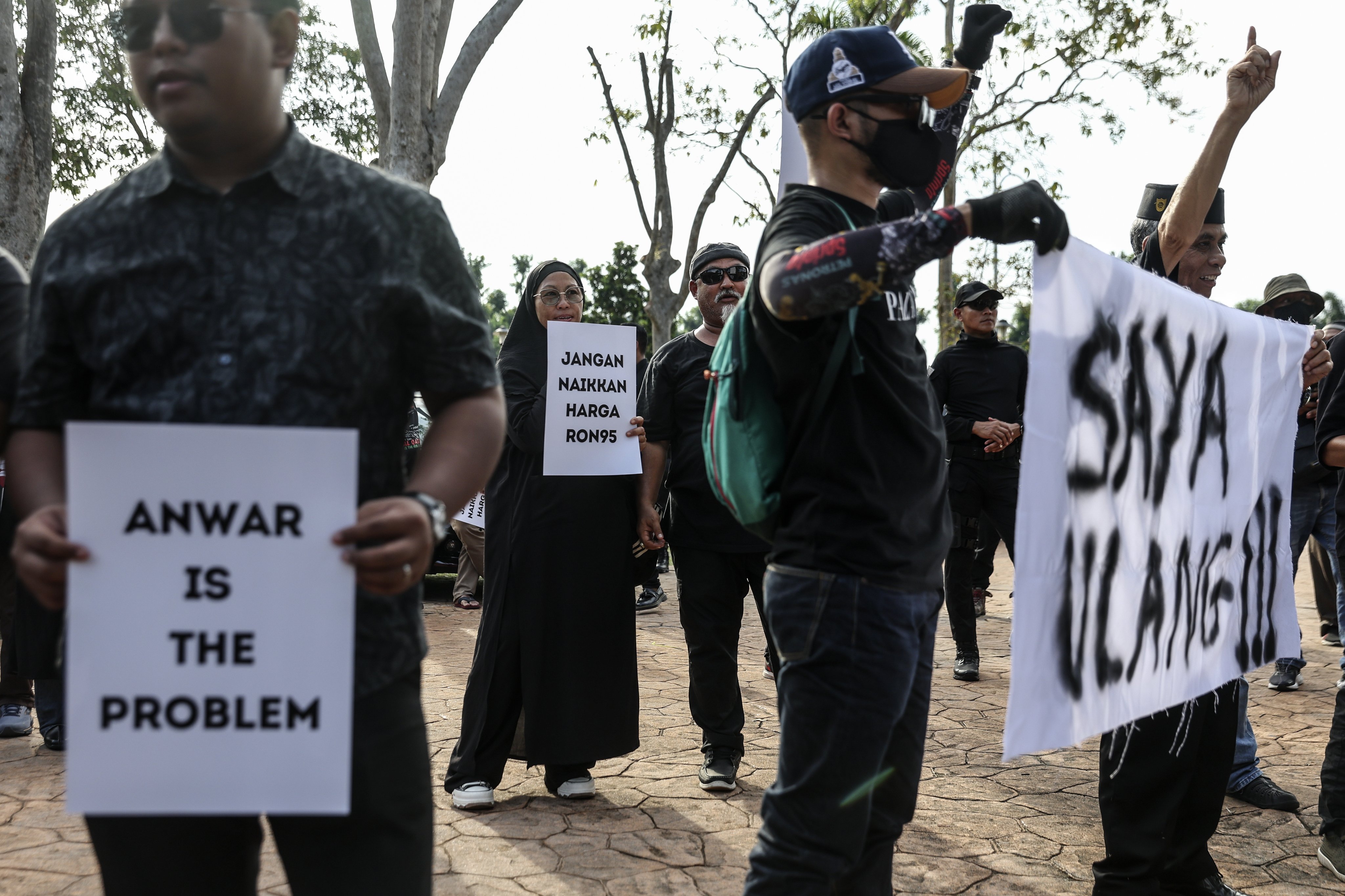 Protesters hold placards outside the Malaysian PM’s official residence  in Putrajaya to demand for lower diesel prices. Photo: EPA-EFE