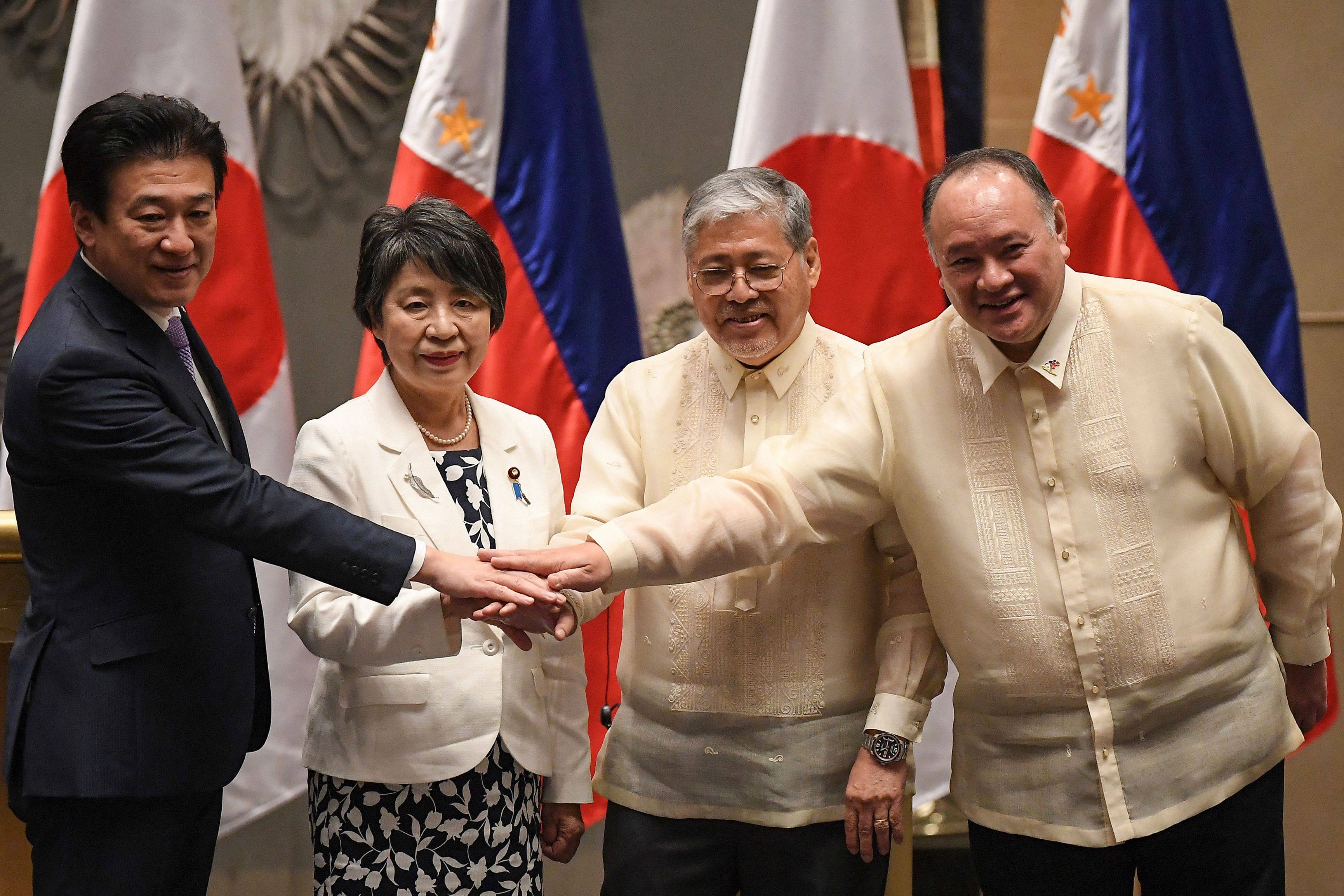 From left: Japan’s Defence Minister Minoru Kihara and Foreign Minister Yoko Kamikawa join hands with Philippine Foreign Secretary Enrique Manalo and Defence Secretary Gilberto Teodoro after a meeting in Manila on July 8. Photo: AFP