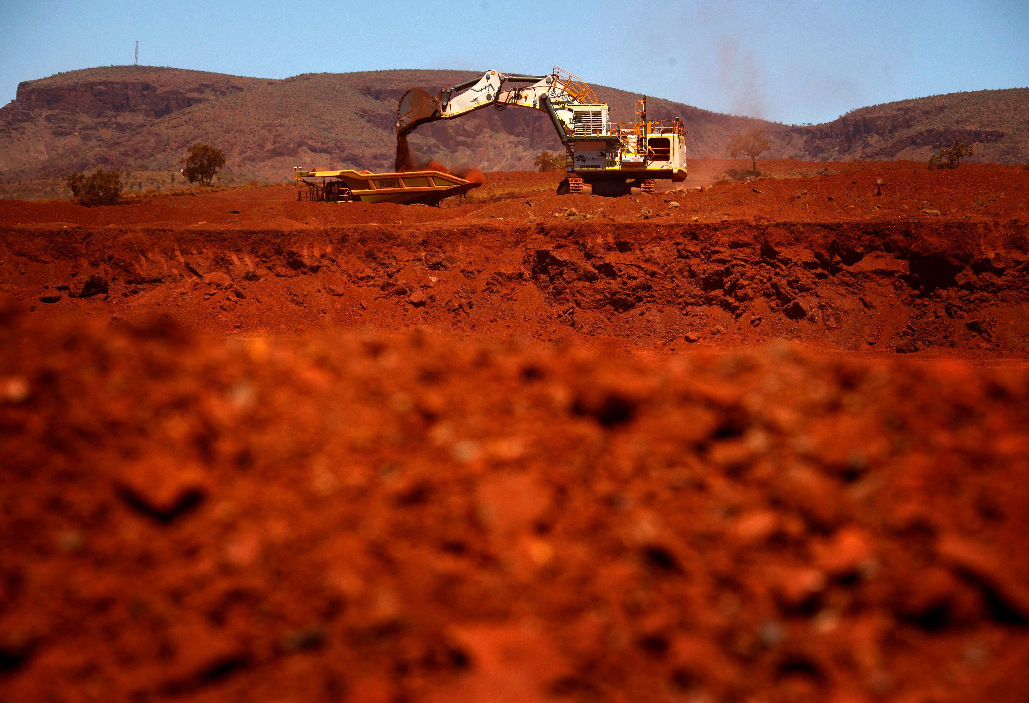 An excavator loads iron ore into a truck at a mine in the Pilbara region of Western Australia. Photo: Reuters