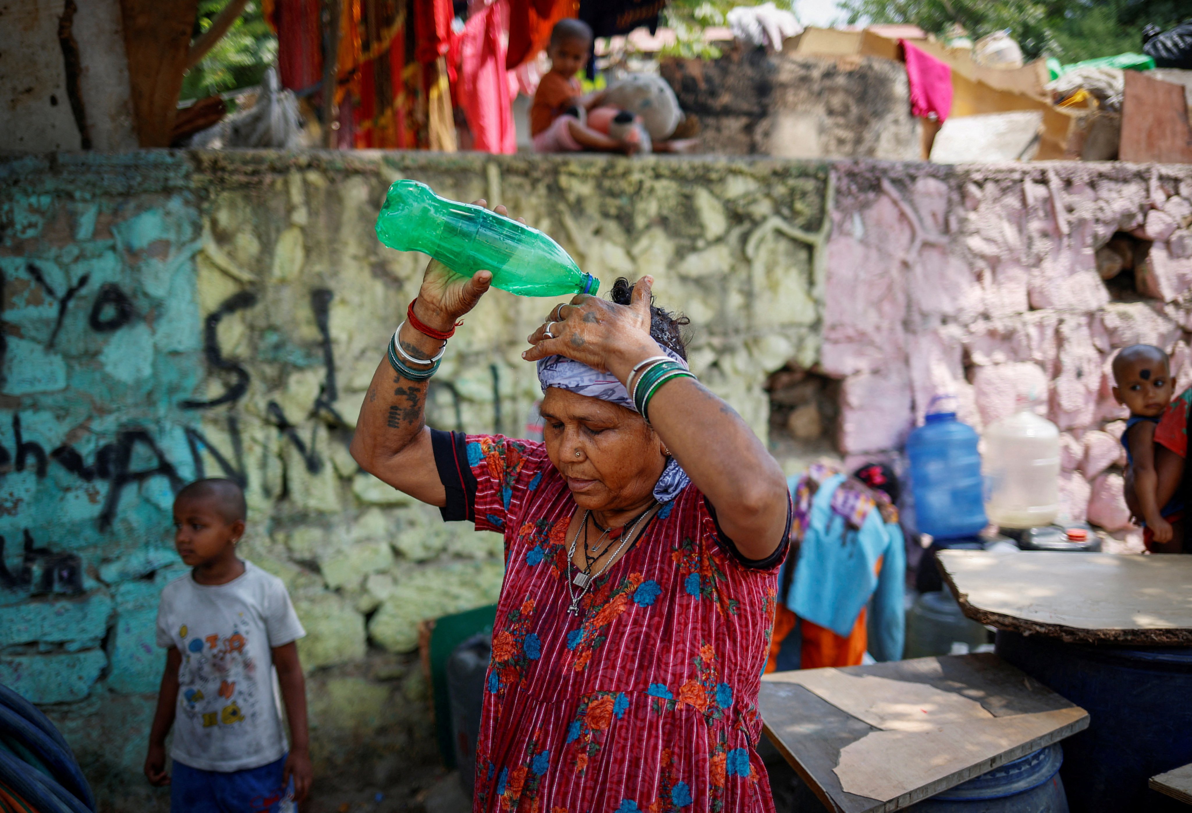 A woman pours water on her head after filling her containers from a municipal tanker on a hot day in New Delhi, India, on May 21. Photo: Reuters