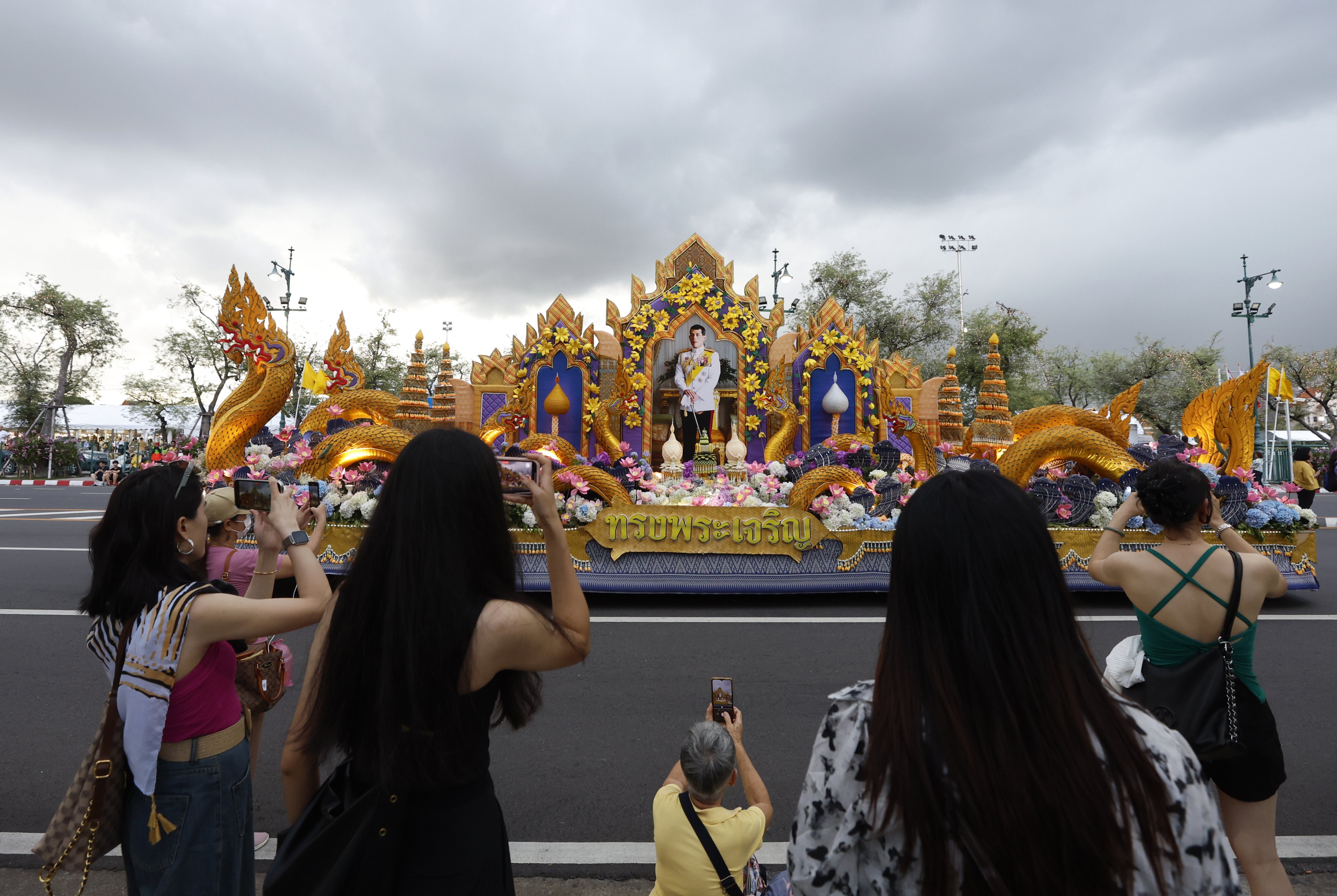 Tourists watch a procession in honour of Thai King Maha Vajiralongkorn’s 72nd birthday in Bangkok on July 11. Photo: EPA-EFE