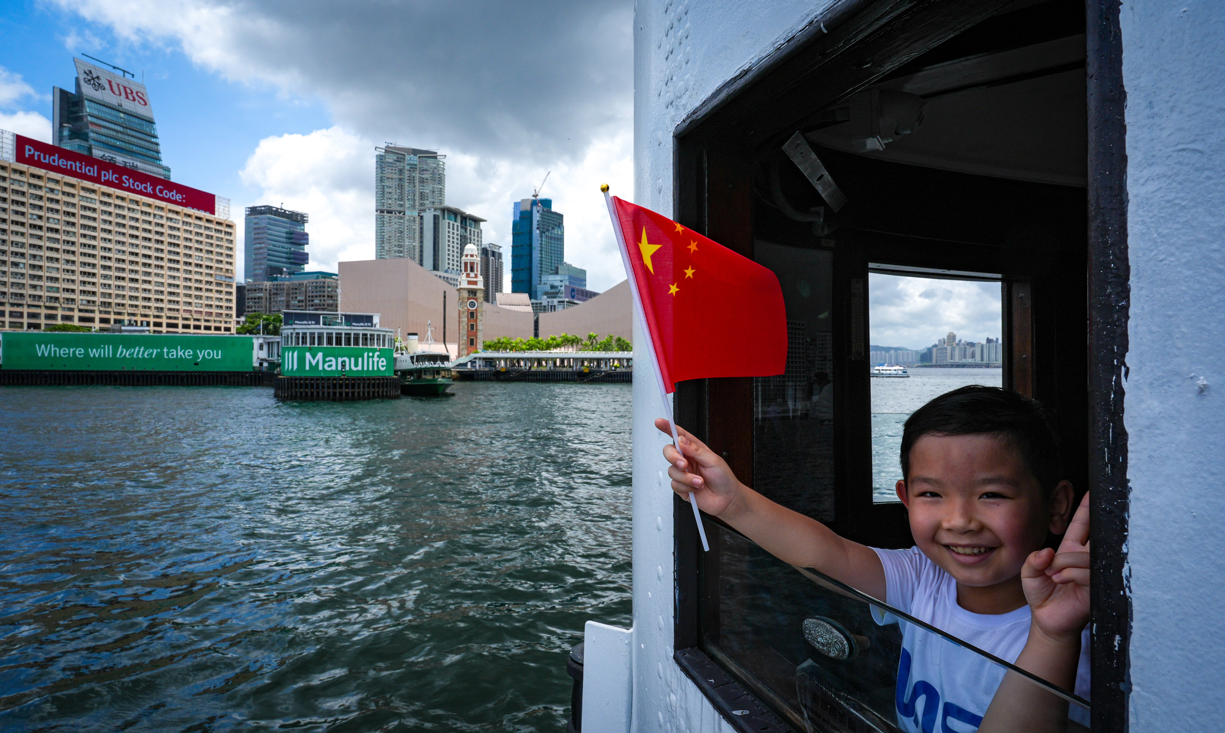 A child waves a mainland Chinese flag while on a ferry from Wan Chai to Tsim Sha Tsui. Photo: Eugene Lee