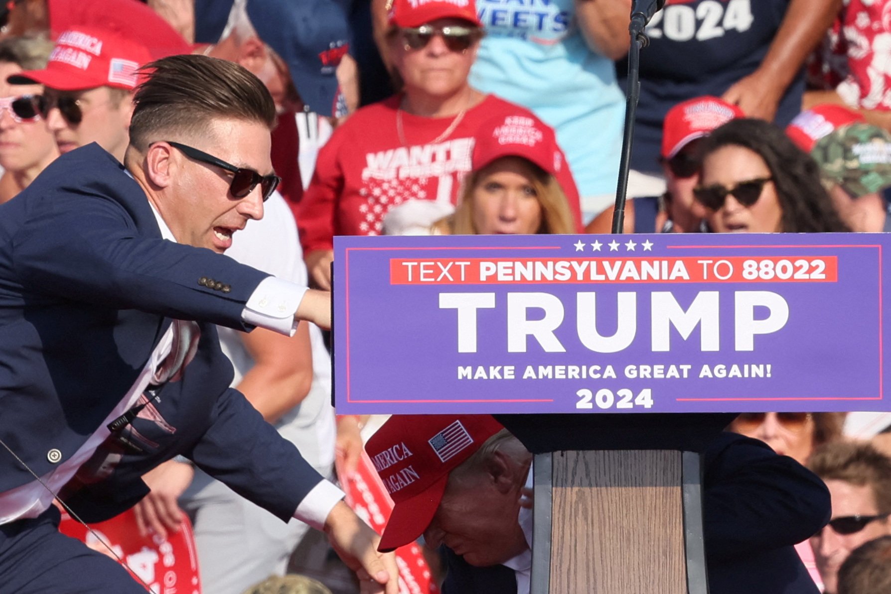 Security personnel reacts as Donald Trump ducks behind the podium after being shot in the ear during a campaign rally at in Pennsylvania on Saturday. Photo: Reuters