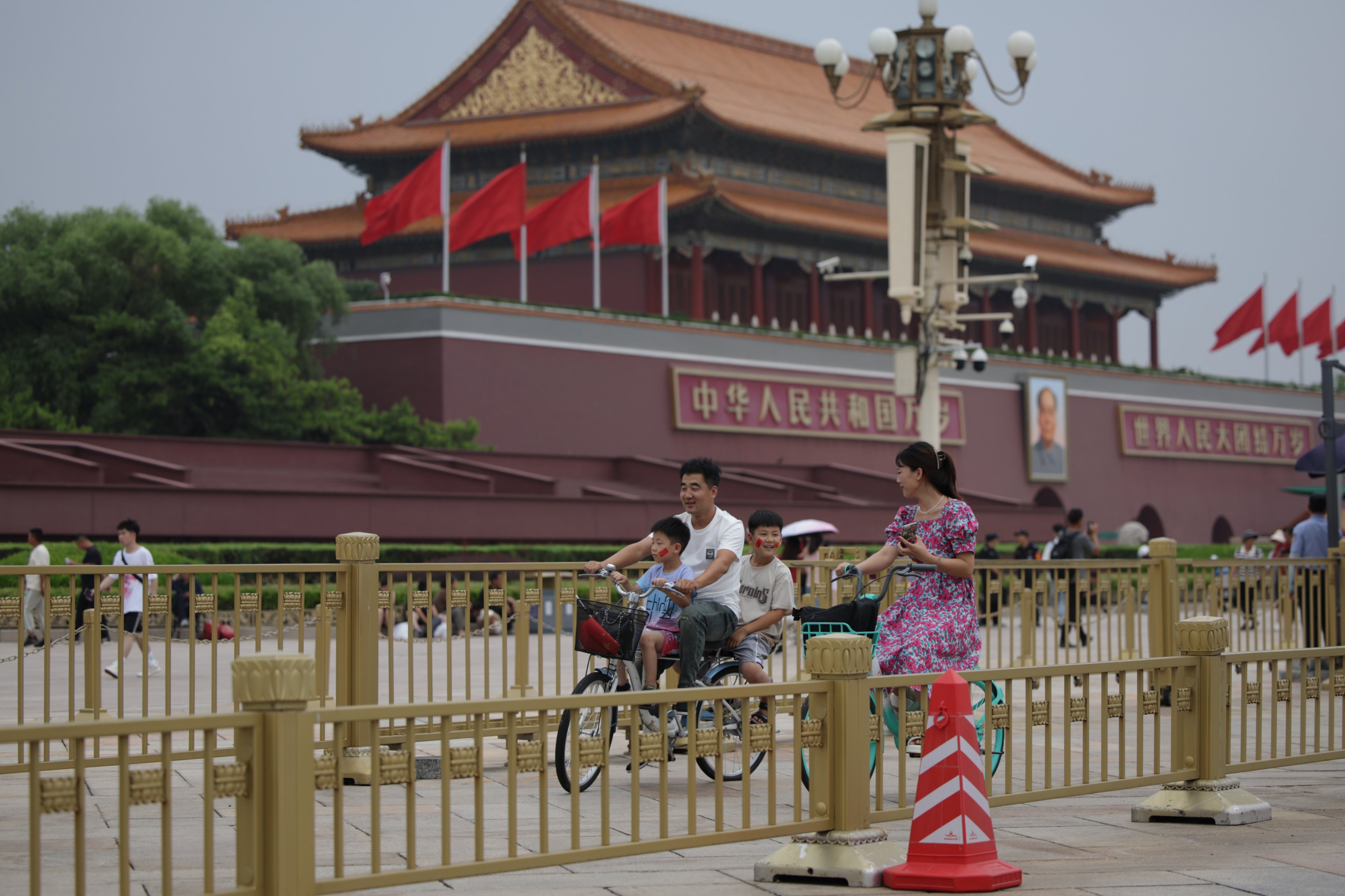 People ride a bicycle near Tiananmen Square as China’s communist party holds its third plenum in Beijing, China on July 15, 2024. Photo: EPA-EFE