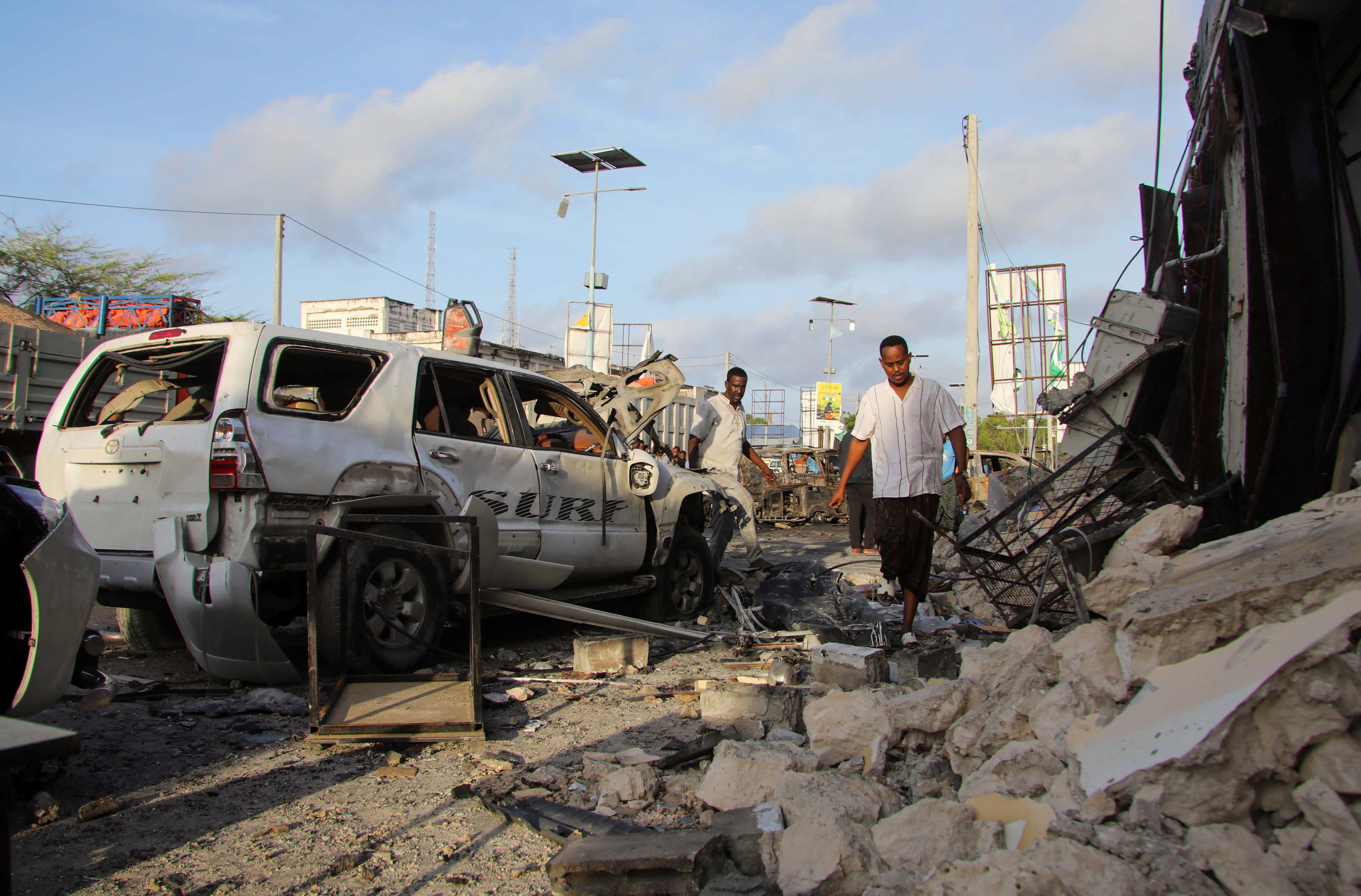 People gather near the wreckages of vehicles destroyed at the scene of an explosion outside a restaurant in Mogadishu, in which nine civilians were killed and 20 others wounded. Photo: Reuters